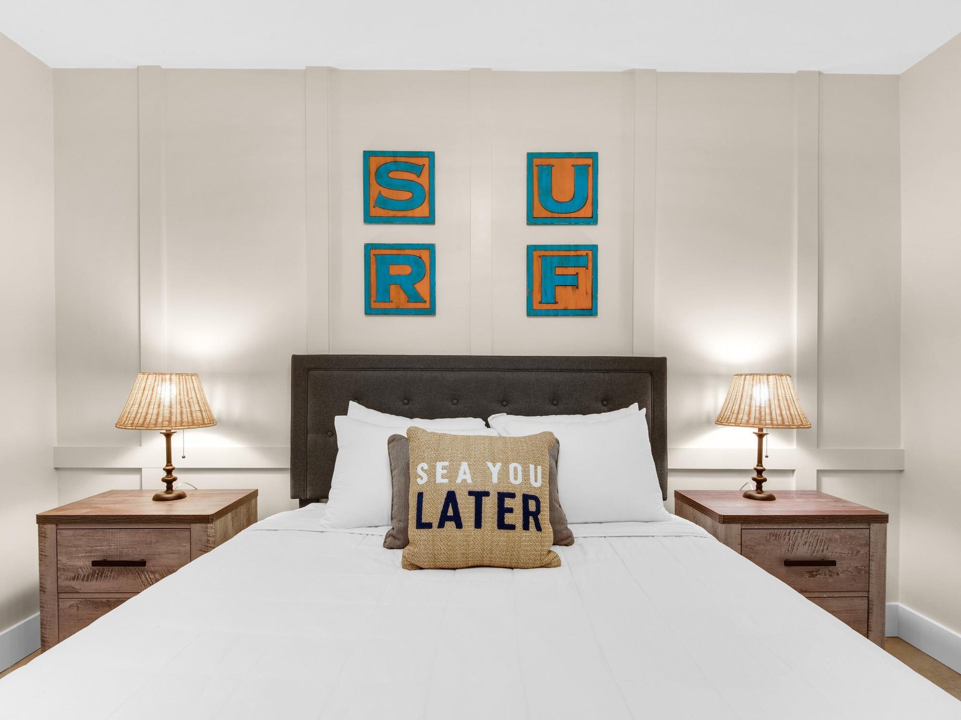 Your coastal bedroom awaits with surfthemed artwork, cozy bedside lamps, and crisp white linens perfect for peaceful rest.