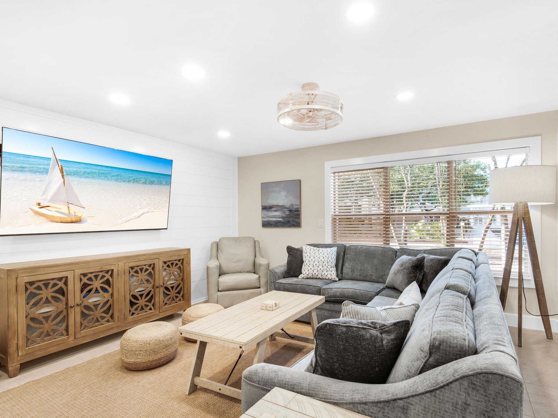 Coastalthemed living space with plush sectional seating and peaceful beach artwork setting the perfect vacation mood.
