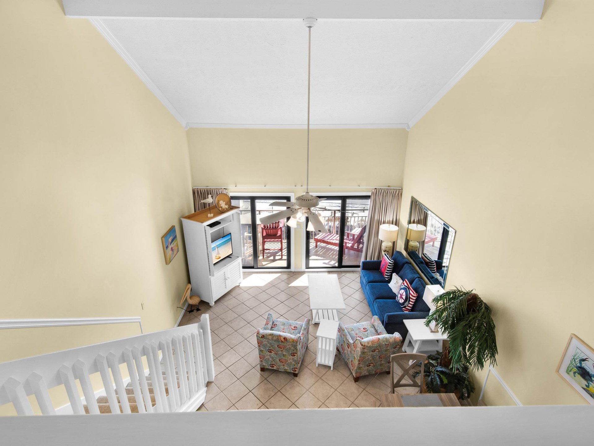 The spacious living room opens to a private balcony with coastal charm, featuring comfortable seating and nautical touches throughout.