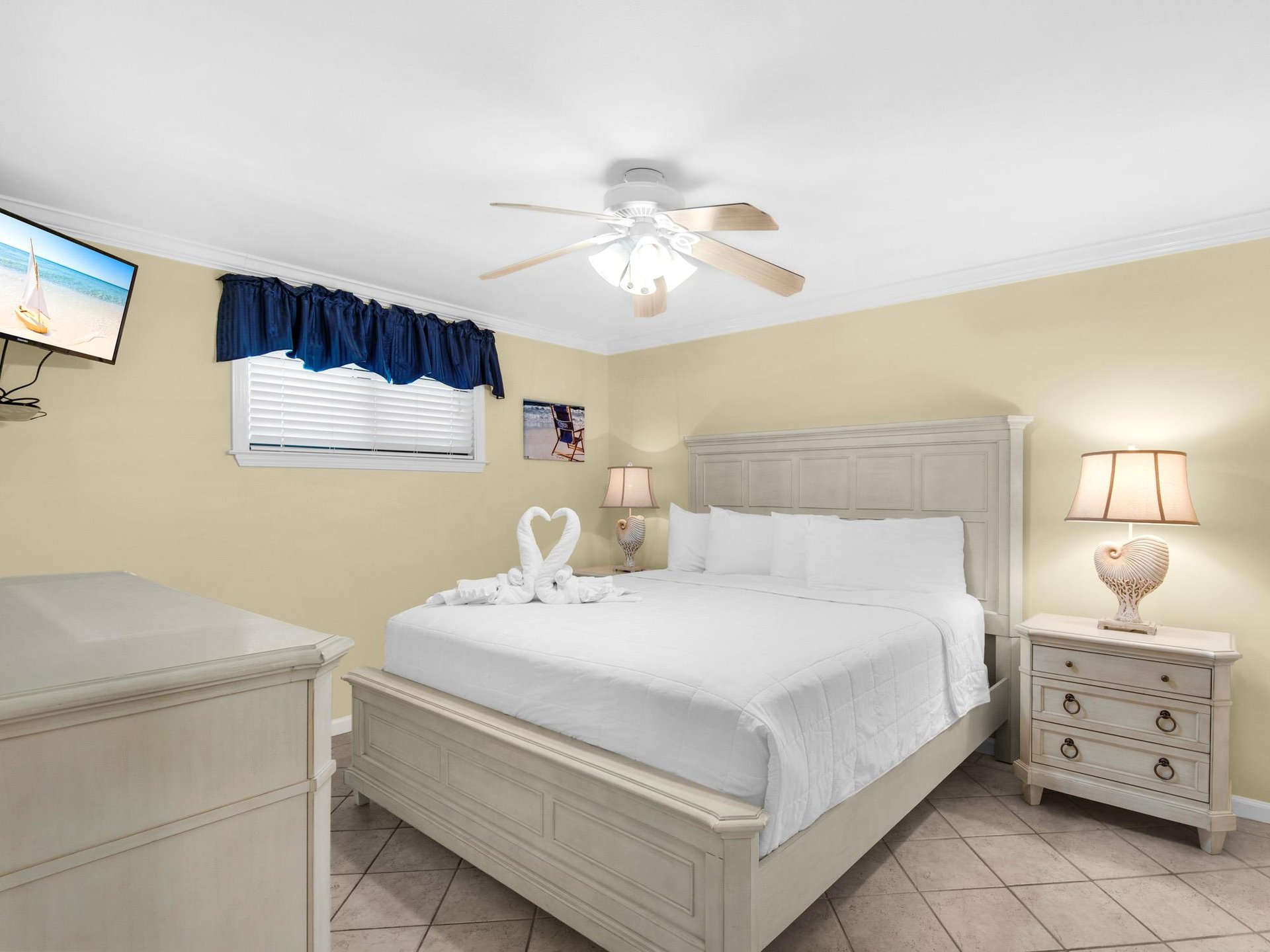 Drift off to sleep in your cozy bedroom with crisp linens, thoughtful towel swans, and gentle ceiling fan breeze.