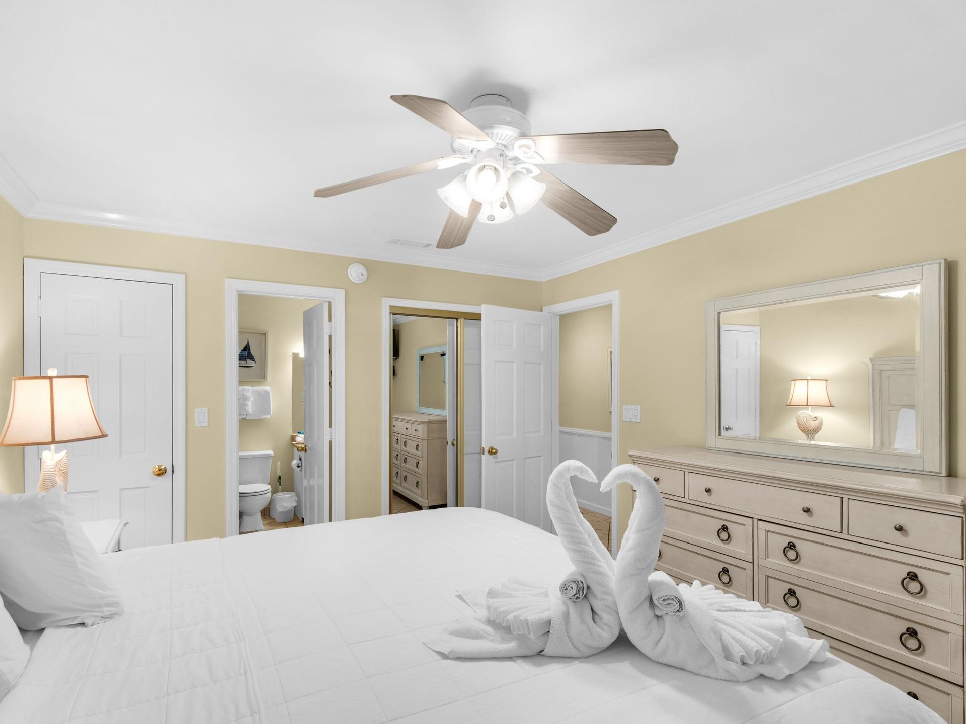 Your peaceful bedroom sanctuary features a comfortable bed, elegant furnishings, and charming towel swans awaiting your arrival.