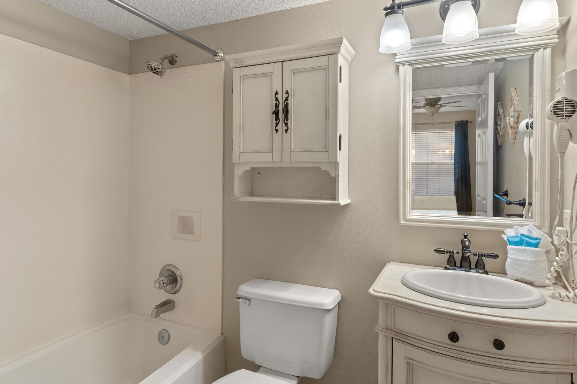 Bathroom 1 features a relaxing tub, modern vanity with mirror, and thoughtful storage to keep your essentials organized during your stay.
