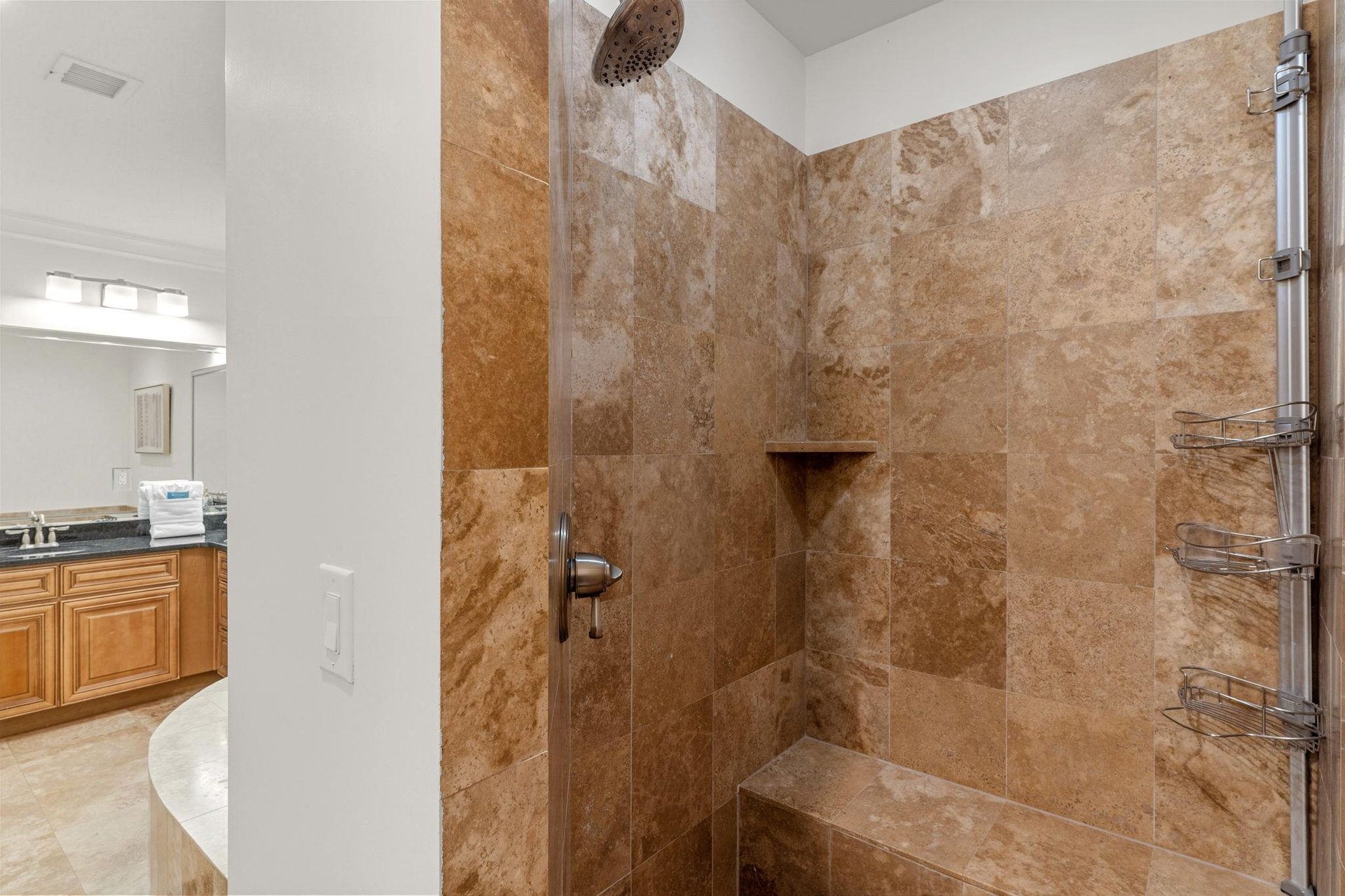 Step into your luxurious shower featuring a rainfall head and builtin bench for the ultimate relaxation experience.
