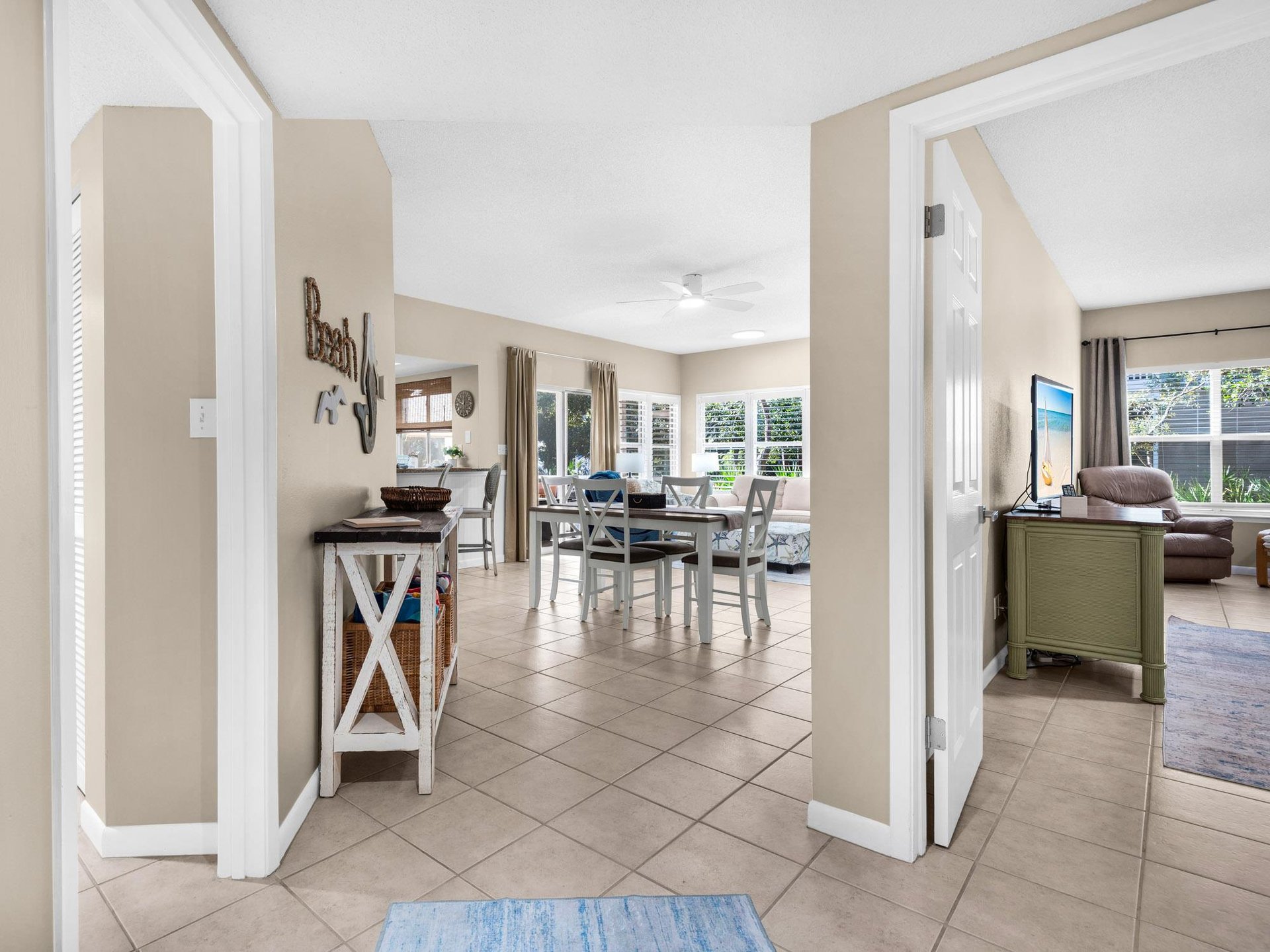 Step into your bright, open living space where coastal charm meets comfort—perfect for gathering around the dining table.