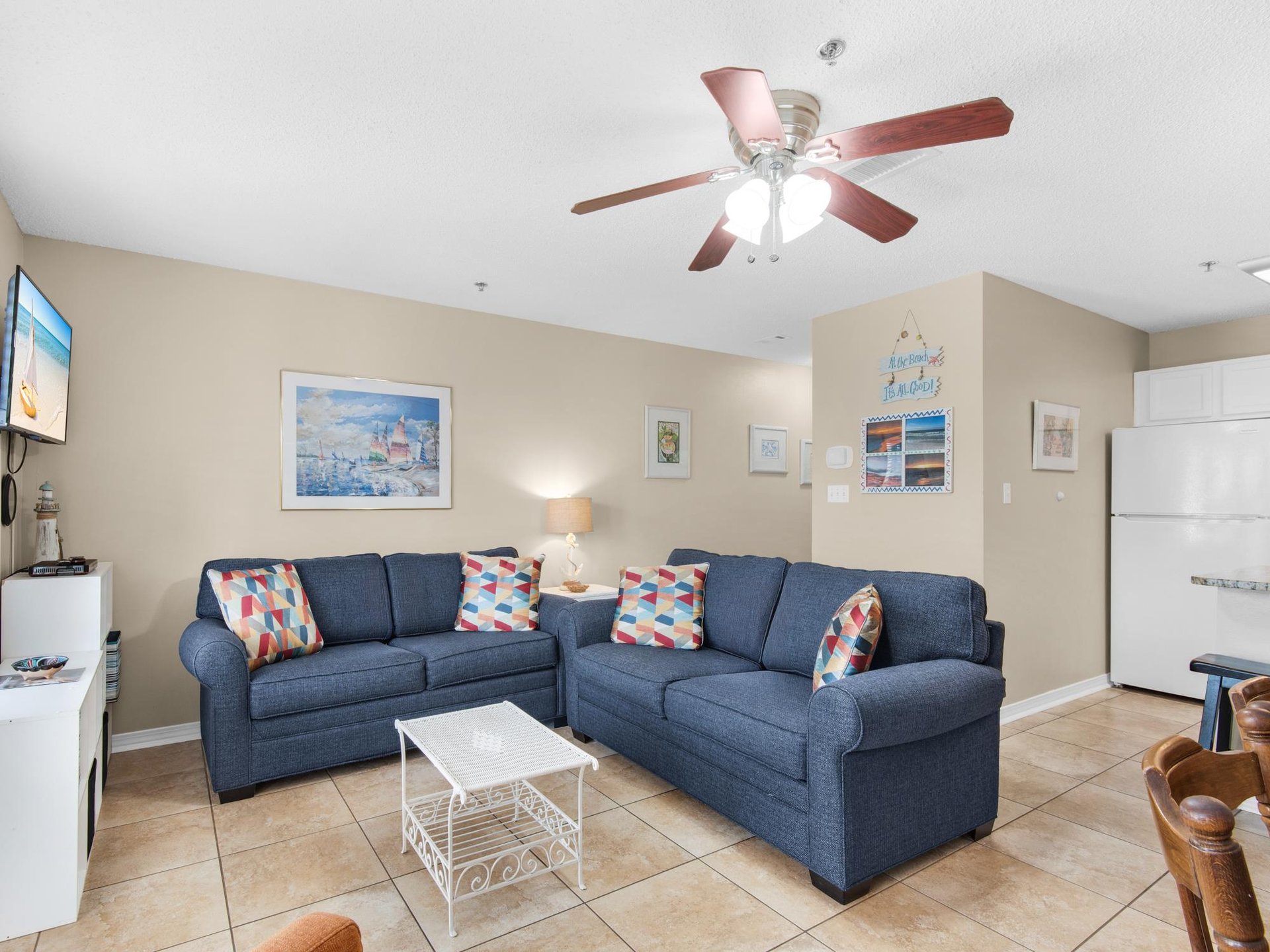 Unwind in the living room with navy seating and cheerful coastal art that sets the perfect beach vacation mood.