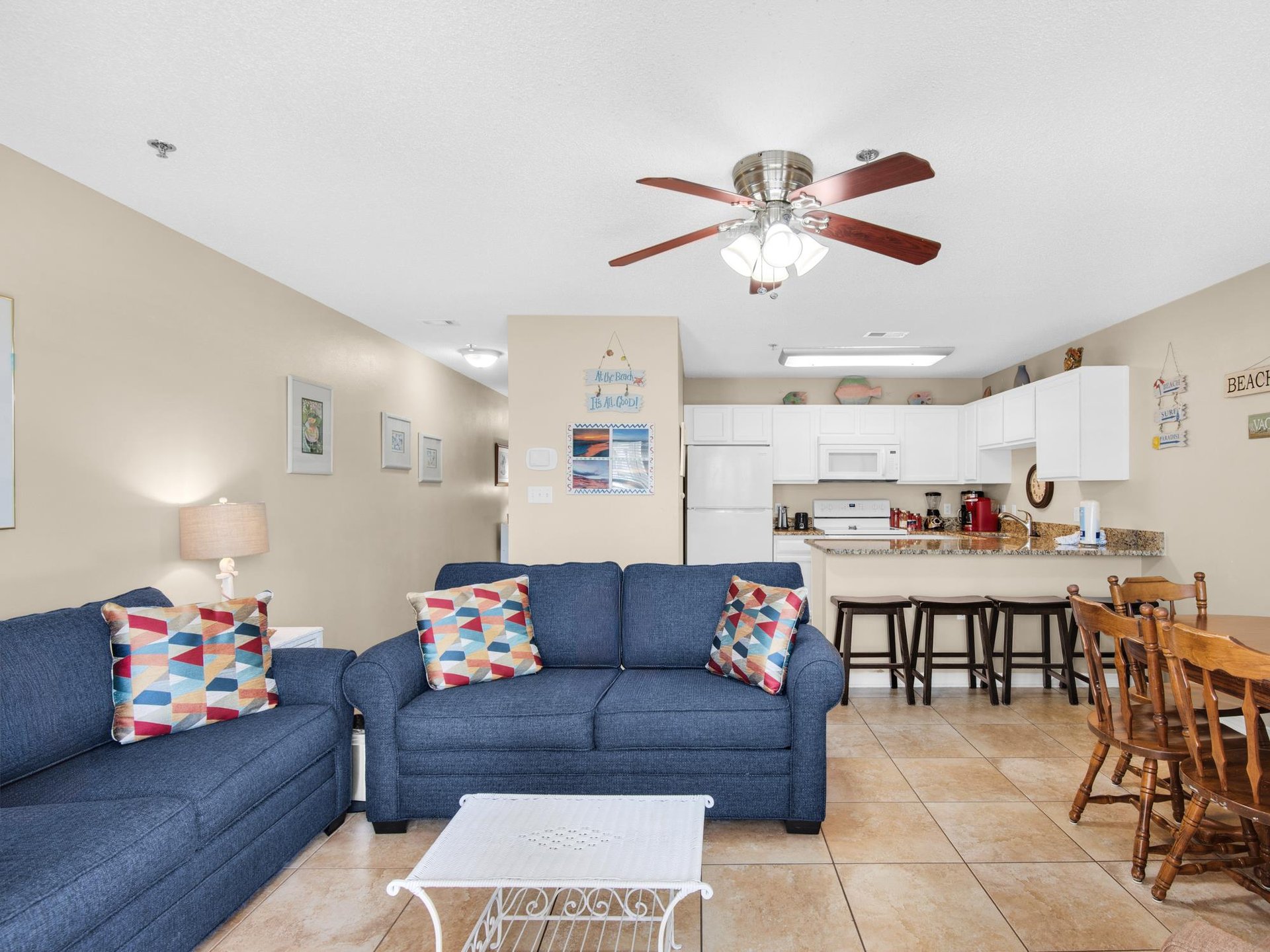 Relax in the comfortable living space with cozy blue sofas and a fully equipped kitchen for family meals together.