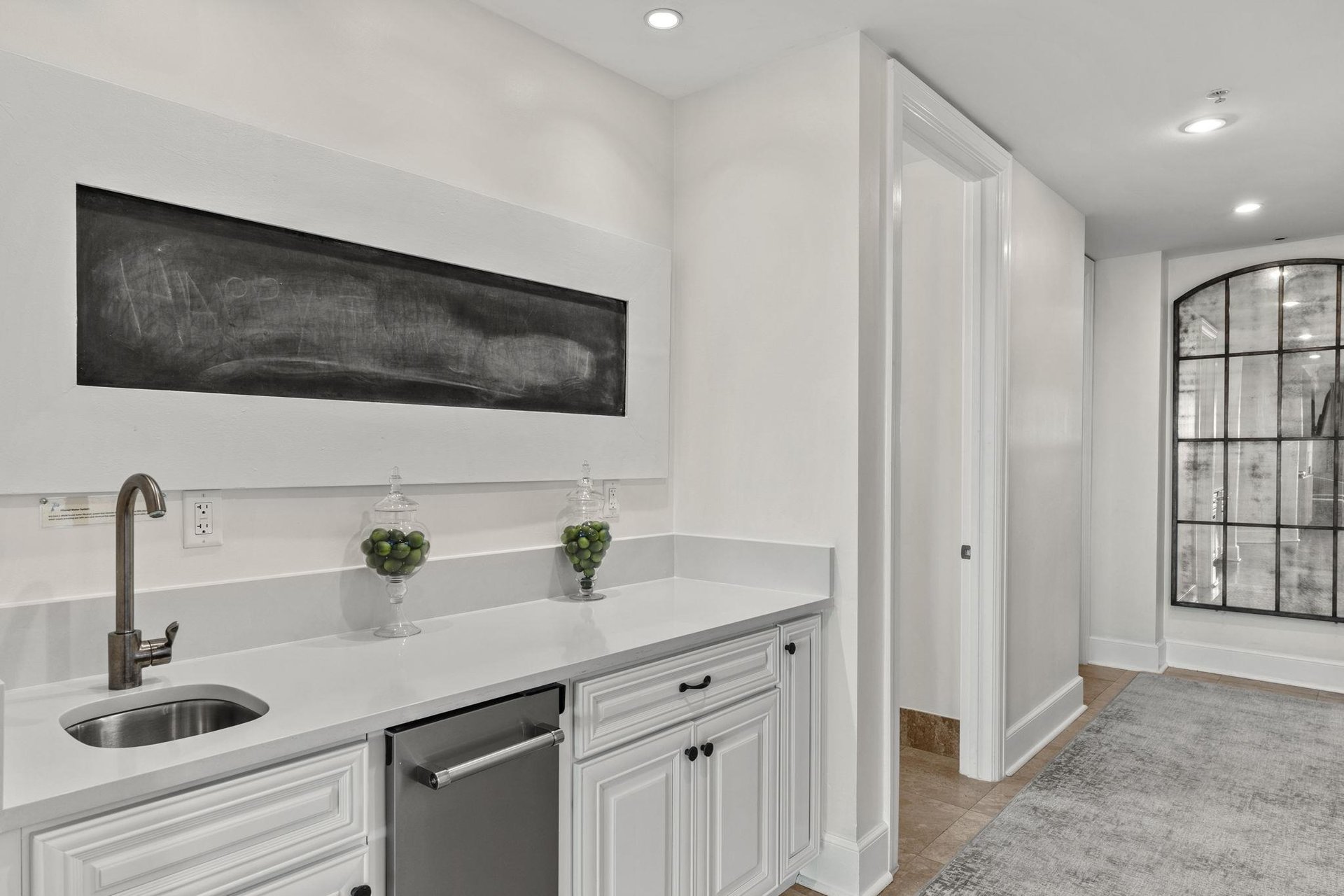 Your elegant kitchenette features pristine white cabinetry, gleaming countertops, and modern appliances for effortless meal prep during your stay.