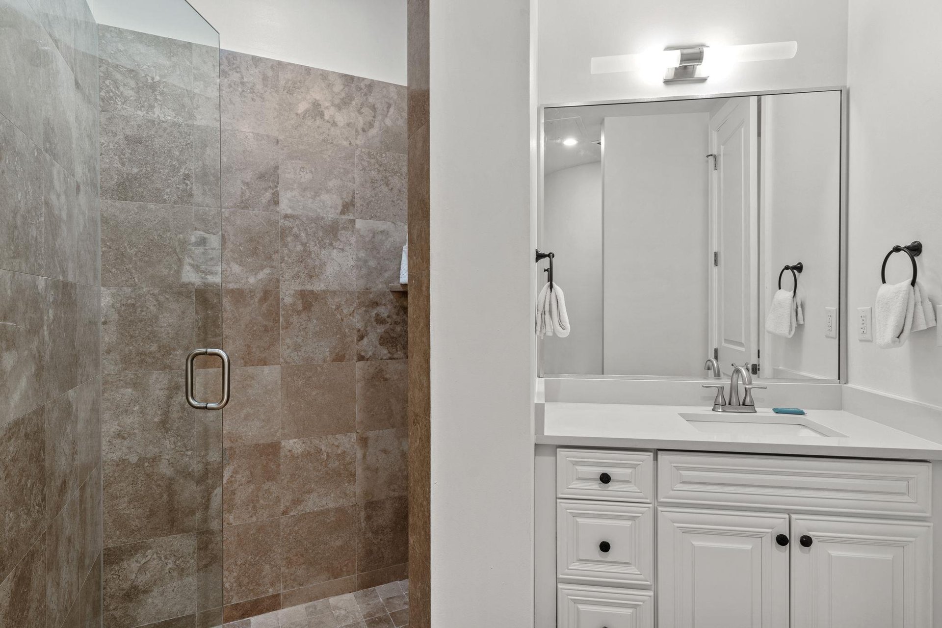 Your private bathroom features elegant stonetiled shower and modern vanity for refreshing starts to your days.