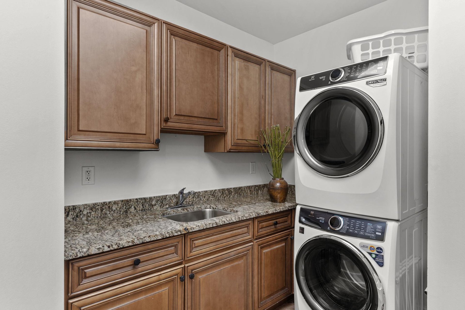 Your private laundry room features granite countertops, ample cabinet storage, and a builtin sink for easy garment care.