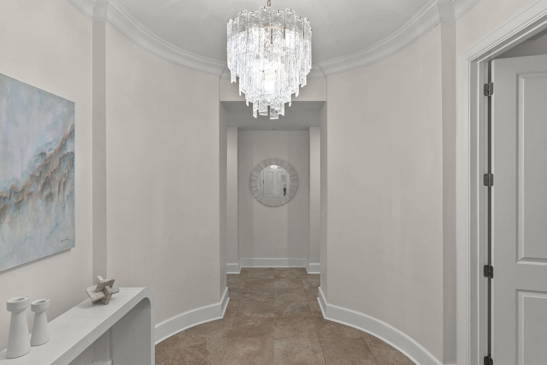 Step into elegant sophistication beneath a stunning crystal chandelier that illuminates your grand entrance hallway.
