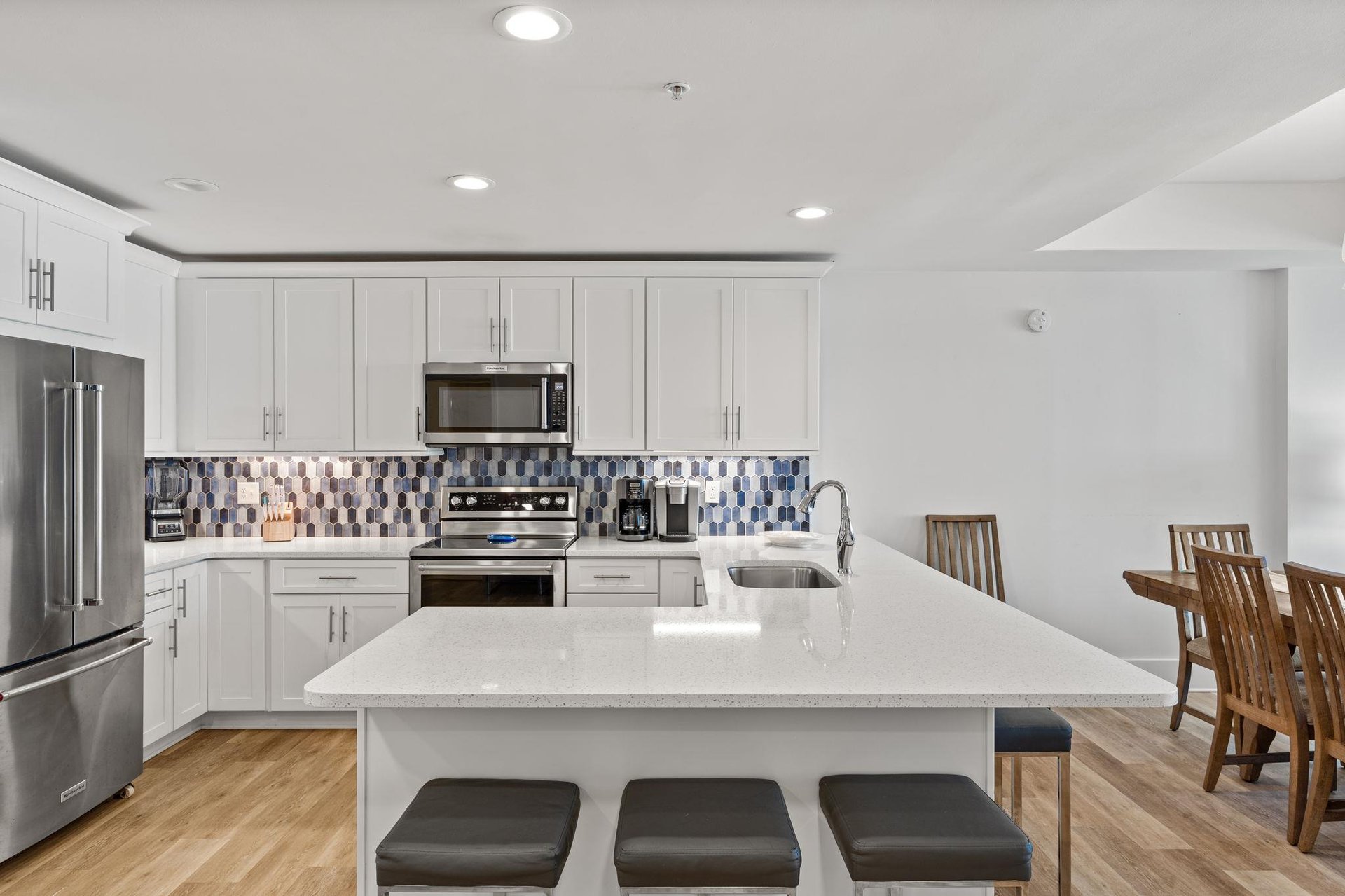 The sleek kitchen features modern appliances,  and a spacious island.