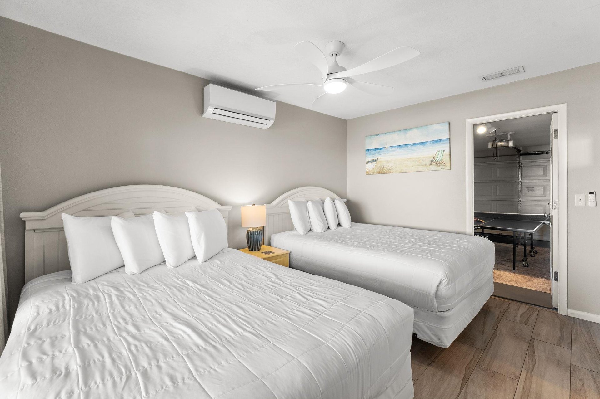 Bedroom 3 offers comfort with two plush Queen beds, climate control, and coastal artwork