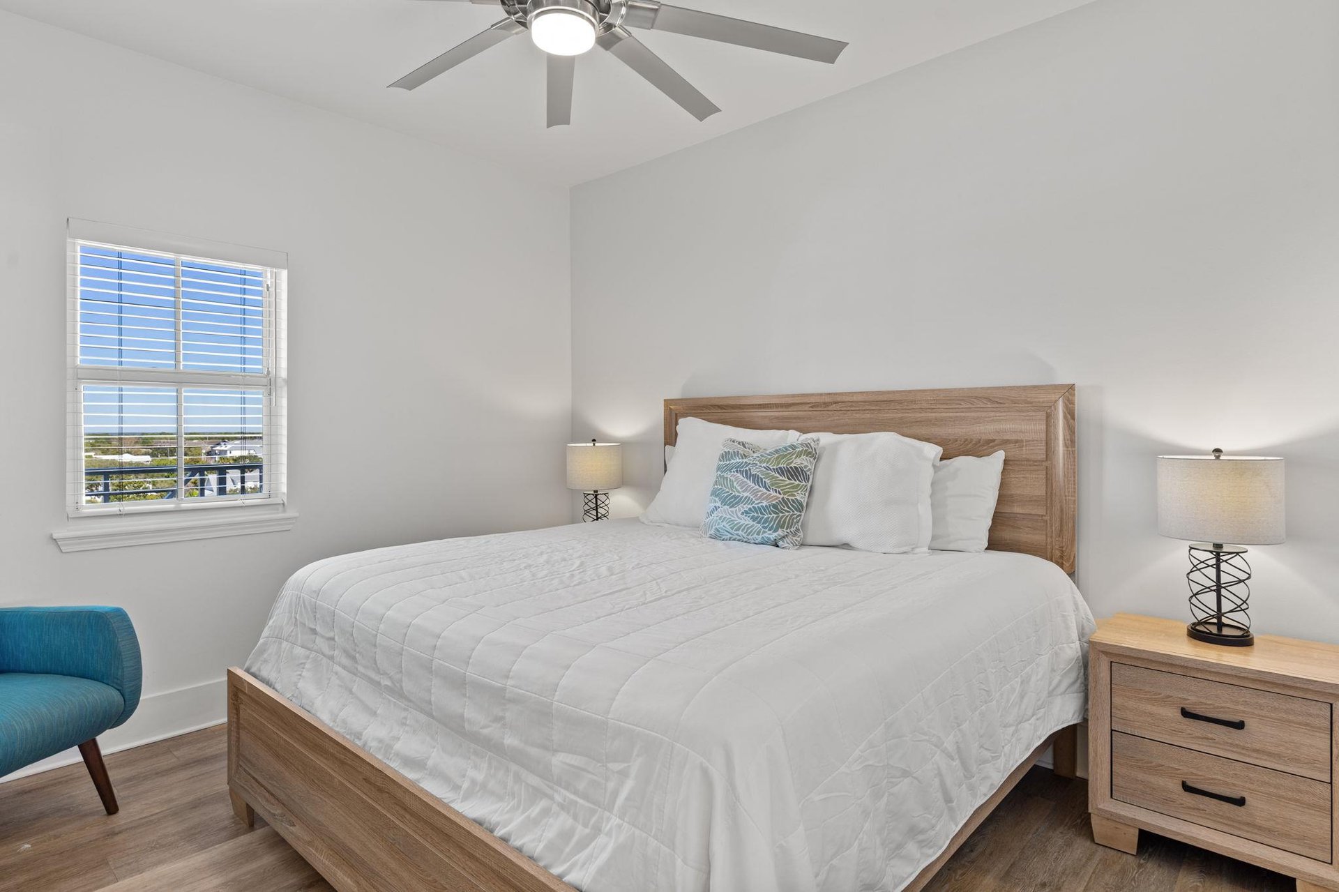 The 1st floor king bedroom with soft linens and warm wood accents.