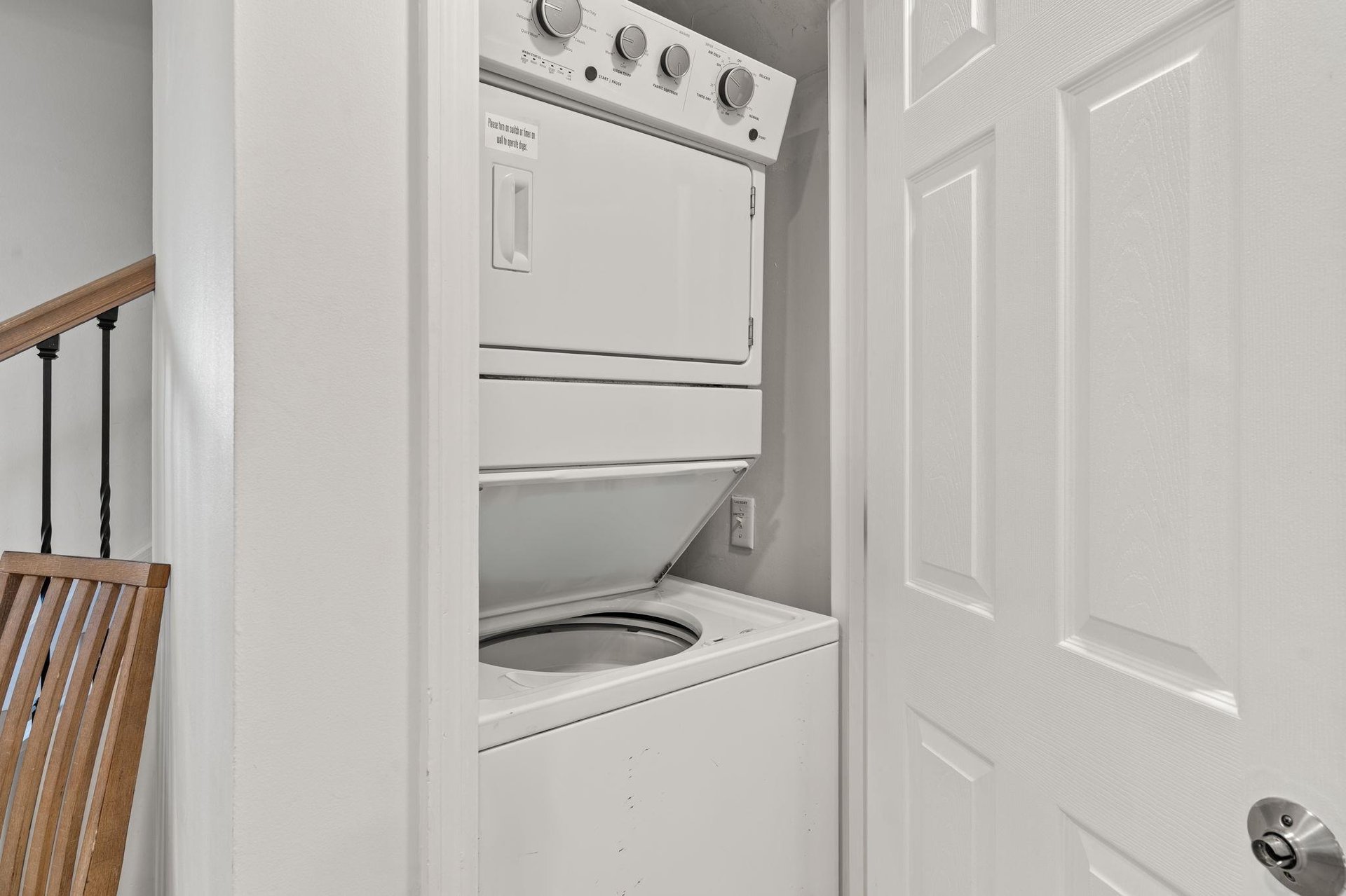 A stackable washer and dryer tucked away in a clean, convenient closet.