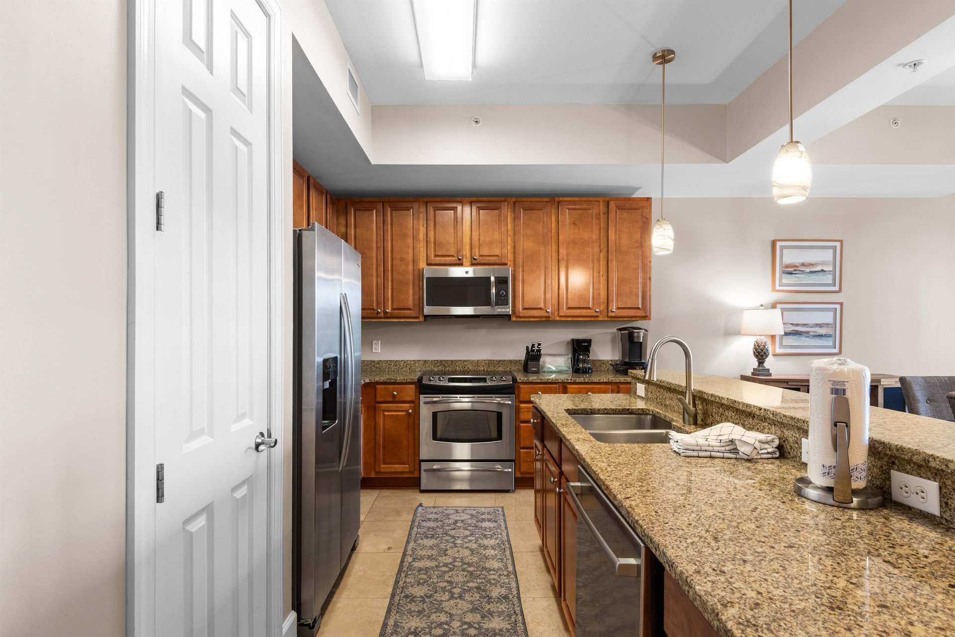 This fully equipped kitchen features granite countertops, stainless steel appliances, and warm wood cabinets for memorable meals.