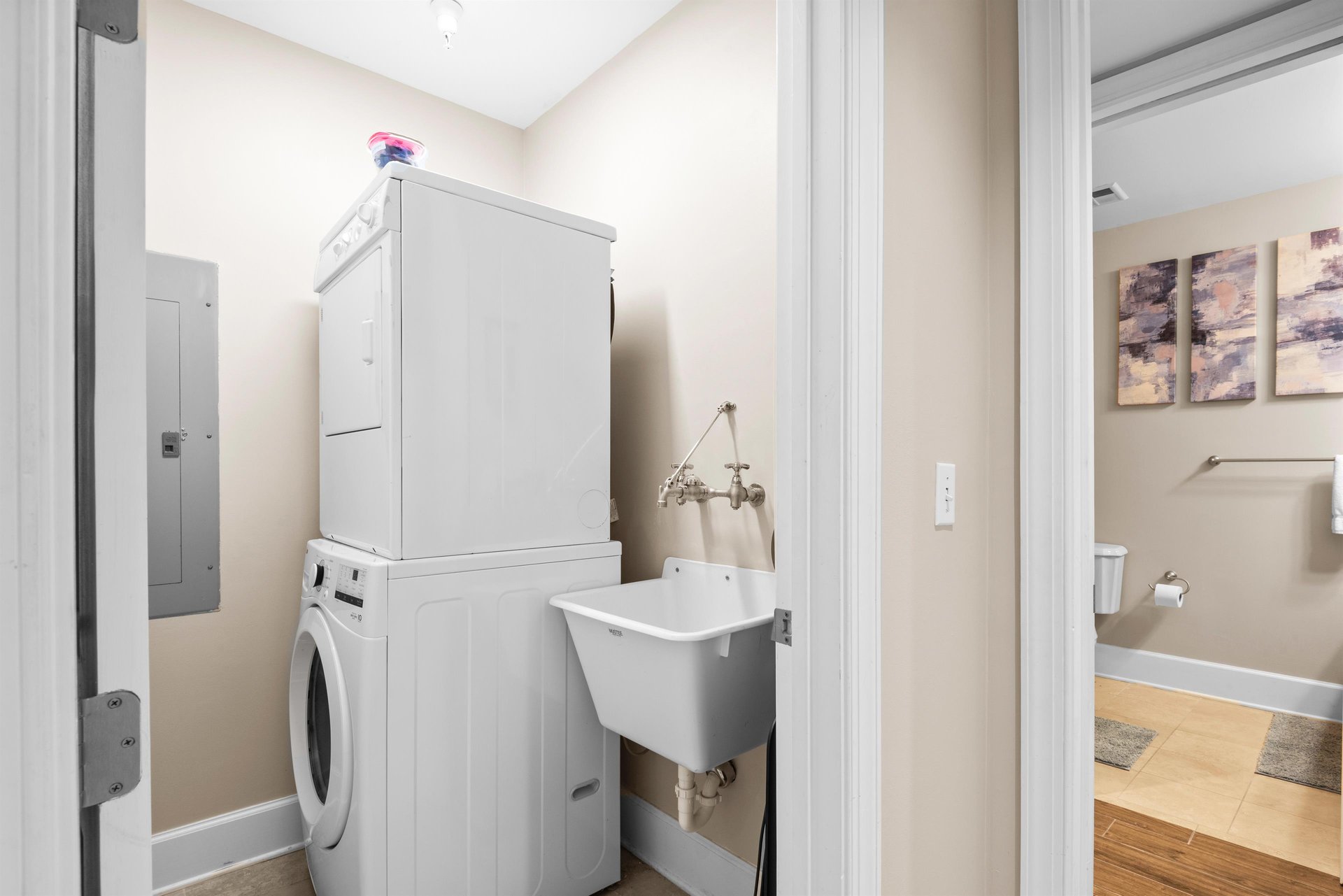 Dedicated laundry space features a stacked washerdryer and utility sink, making longer stays effortless and convenient.