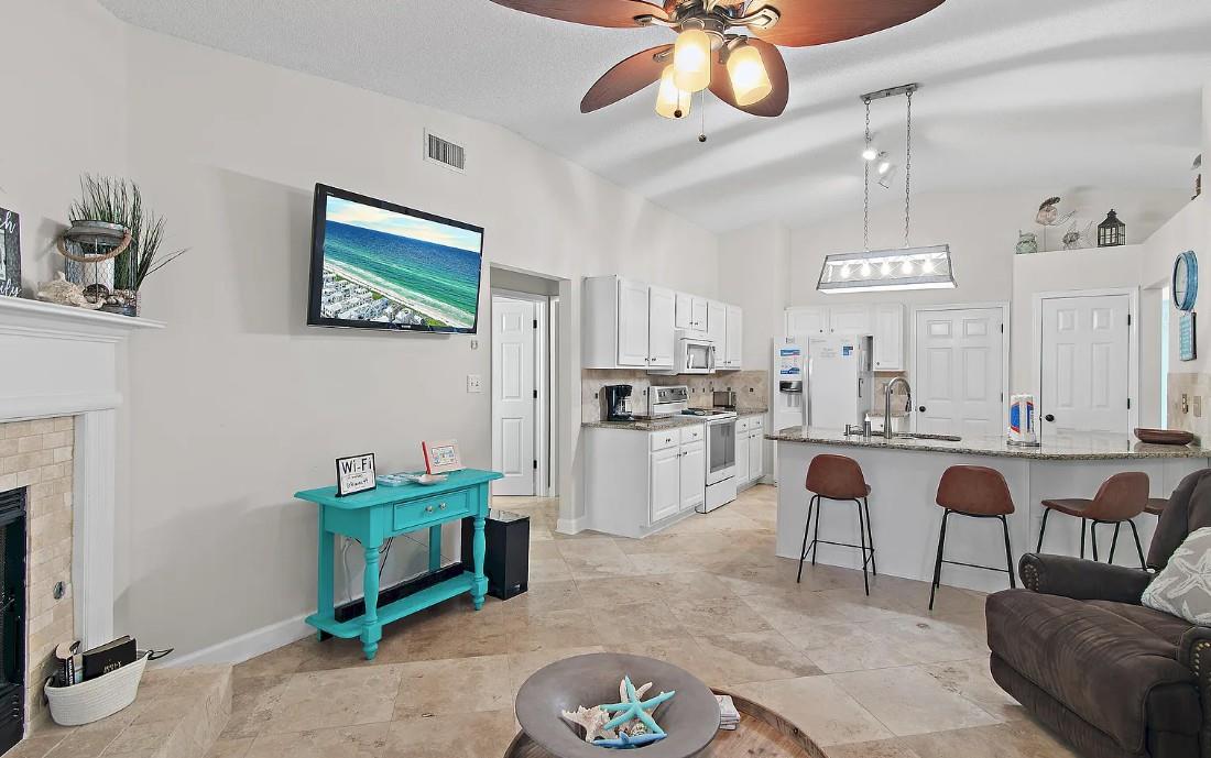 Unwind in your openconcept living space where coastal vibes meet modern comfort, featuring a fully equipped kitchen and cozy seating area.