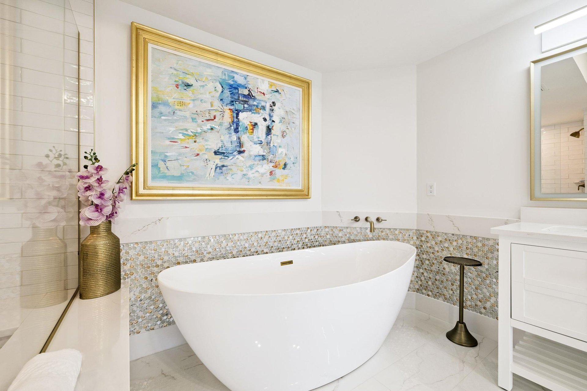 Soak away stress in your elegant freestanding tub, surrounded by sophisticated marble and beautiful art that transforms bath time into pure luxury.