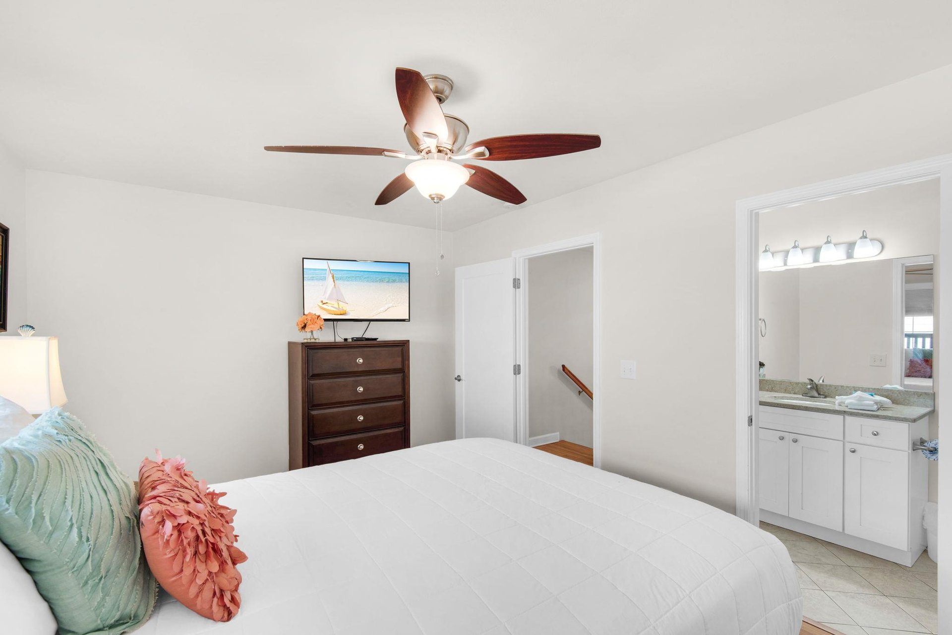 Your bright master bedroom features crisp linens, coastal touches, and an ensuite bathroom for ultimate comfort and convenience.