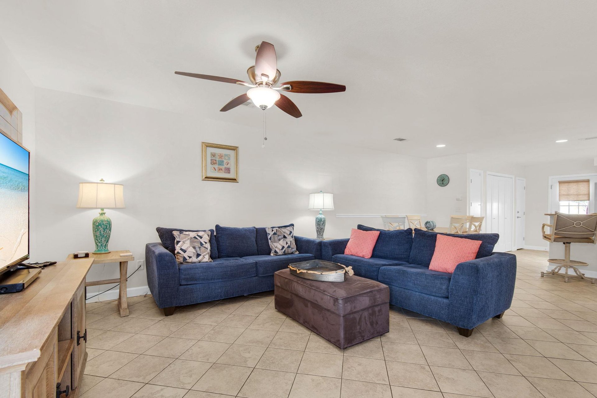The spacious living area has plush navy sectional seating  and seasonal decor