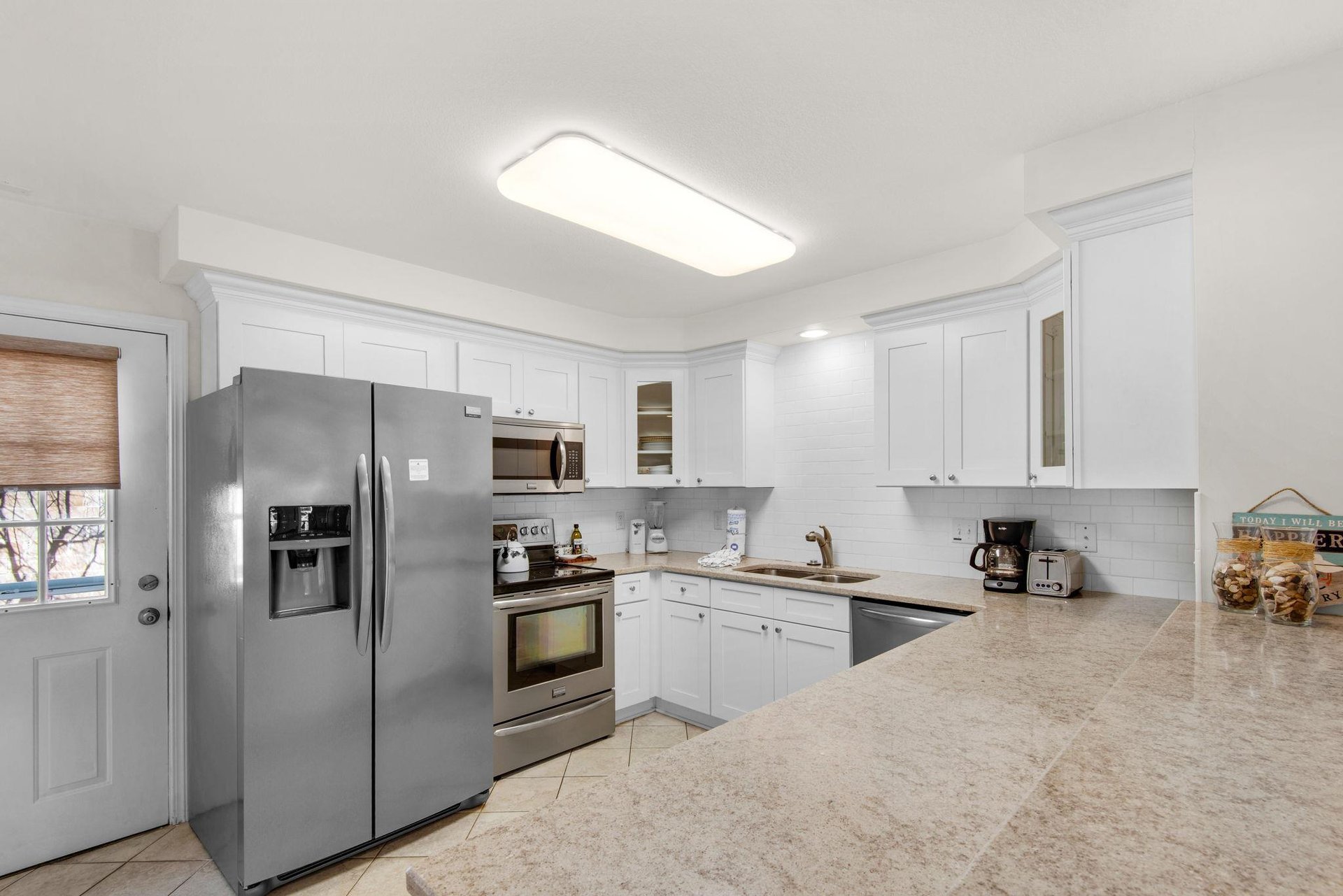 The fully equipped kitchen features granite countertops and stainless steel appliances