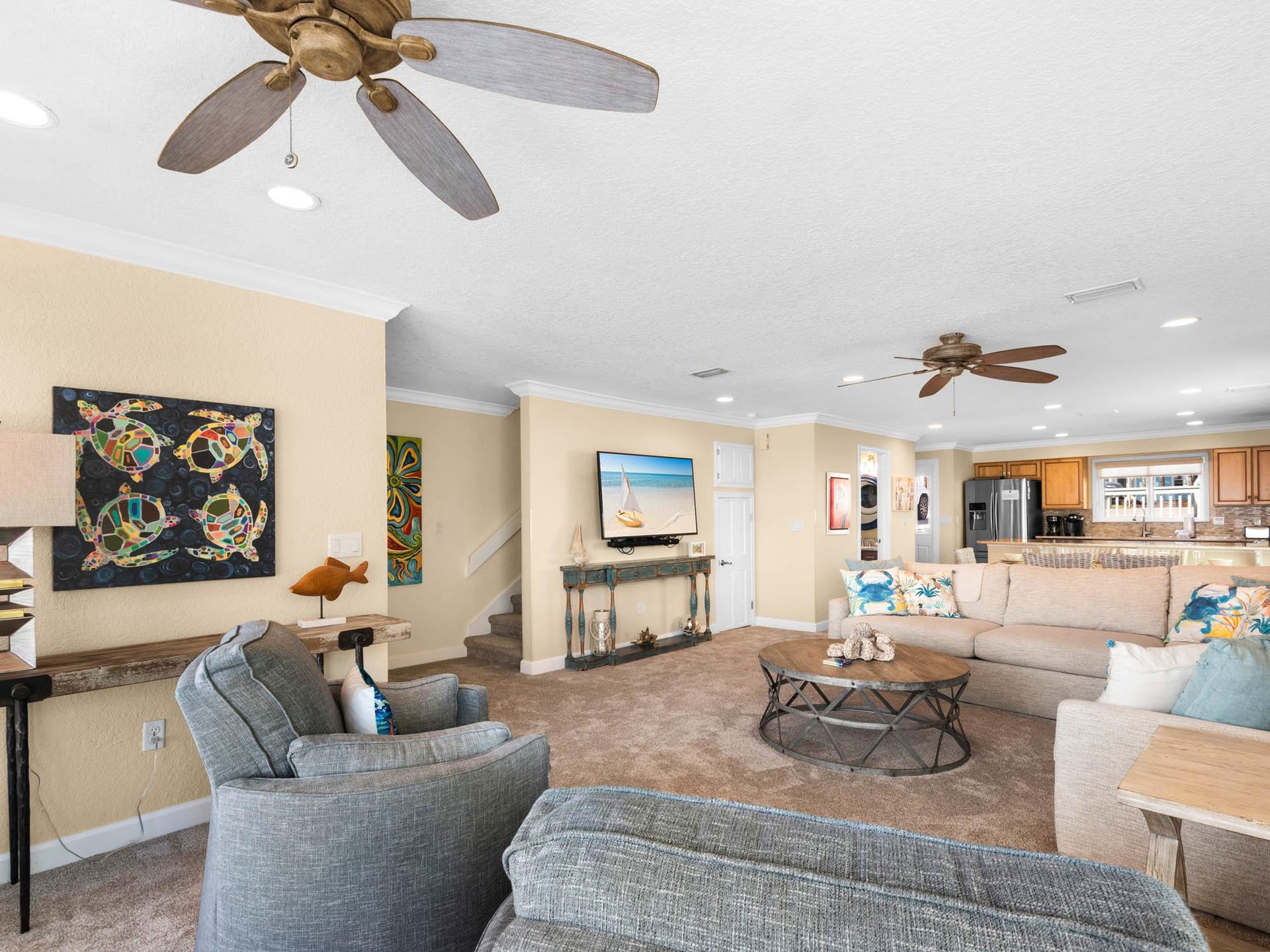 Relax in the spacious living area with coastal décor, comfortable seating, and a fully equipped kitchen.