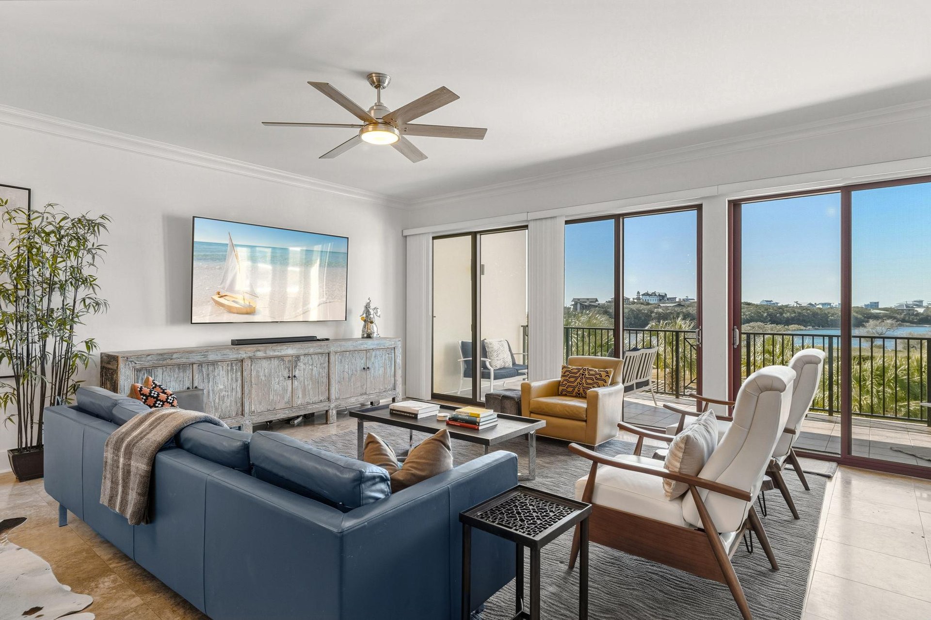 Sink into plush seating and enjoy stunning gulf and lake views from the bright, stylish living room with modern amenities and balcony access.