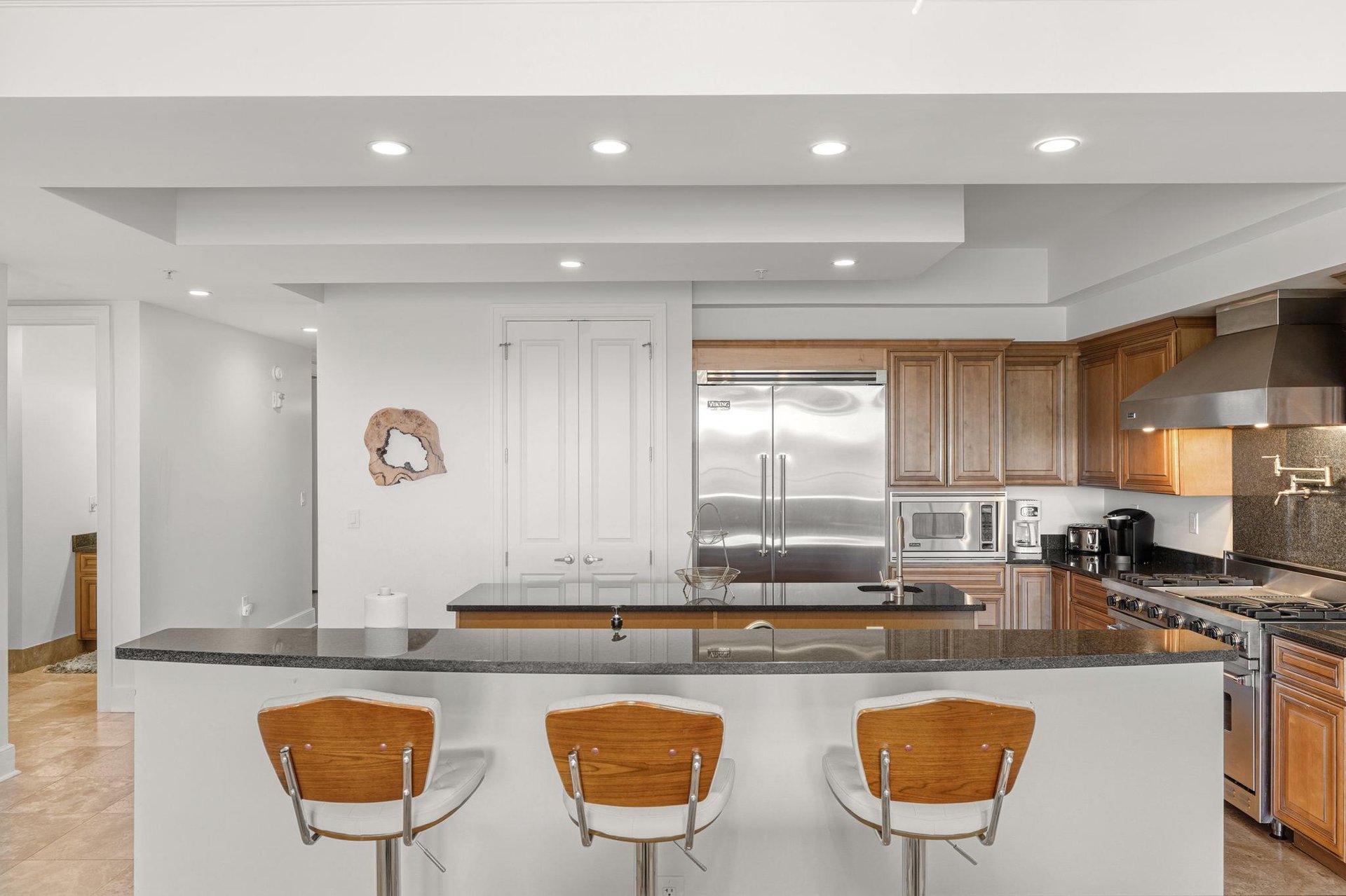 The gourmet kitchen awaits with sleek granite counters, stainless steel appliances, and a breakfast bar perfect for morning coffee.