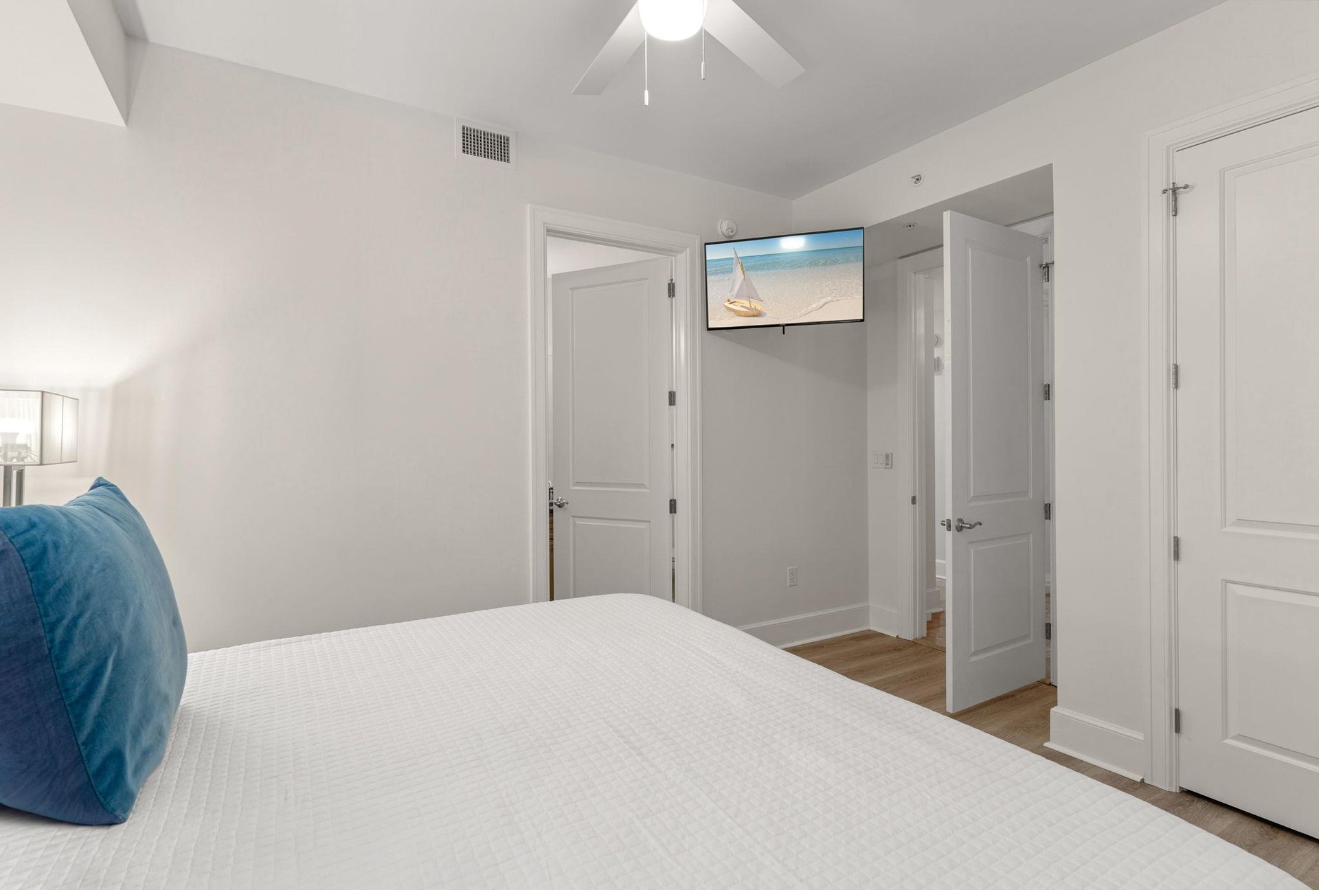 King guest bedroom offers comfort with a wallmounted TV and convenient access to a private bathroom.
