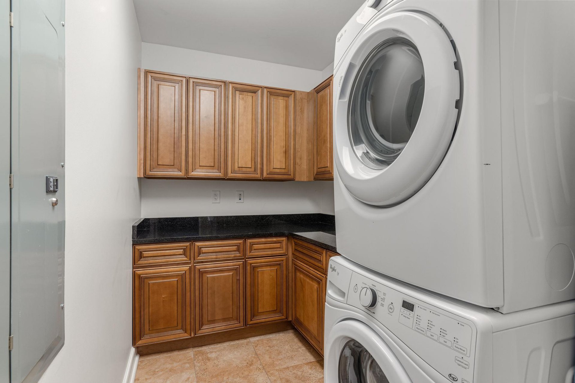 Dedicated laundry room features convenient stackable washer and dryer with cabinet storage for all your linens and supplies.