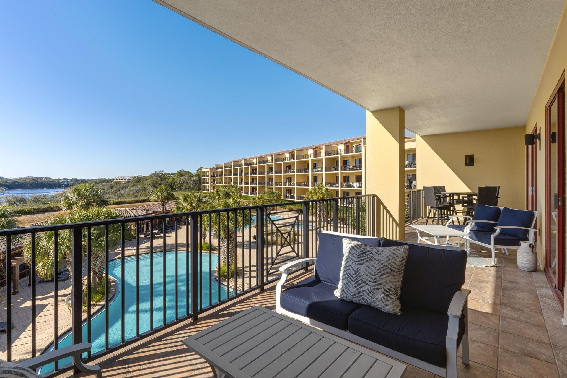 Unwind on 2114 private balcony with stunning pool views, comfortable seating, and gentle breezes.