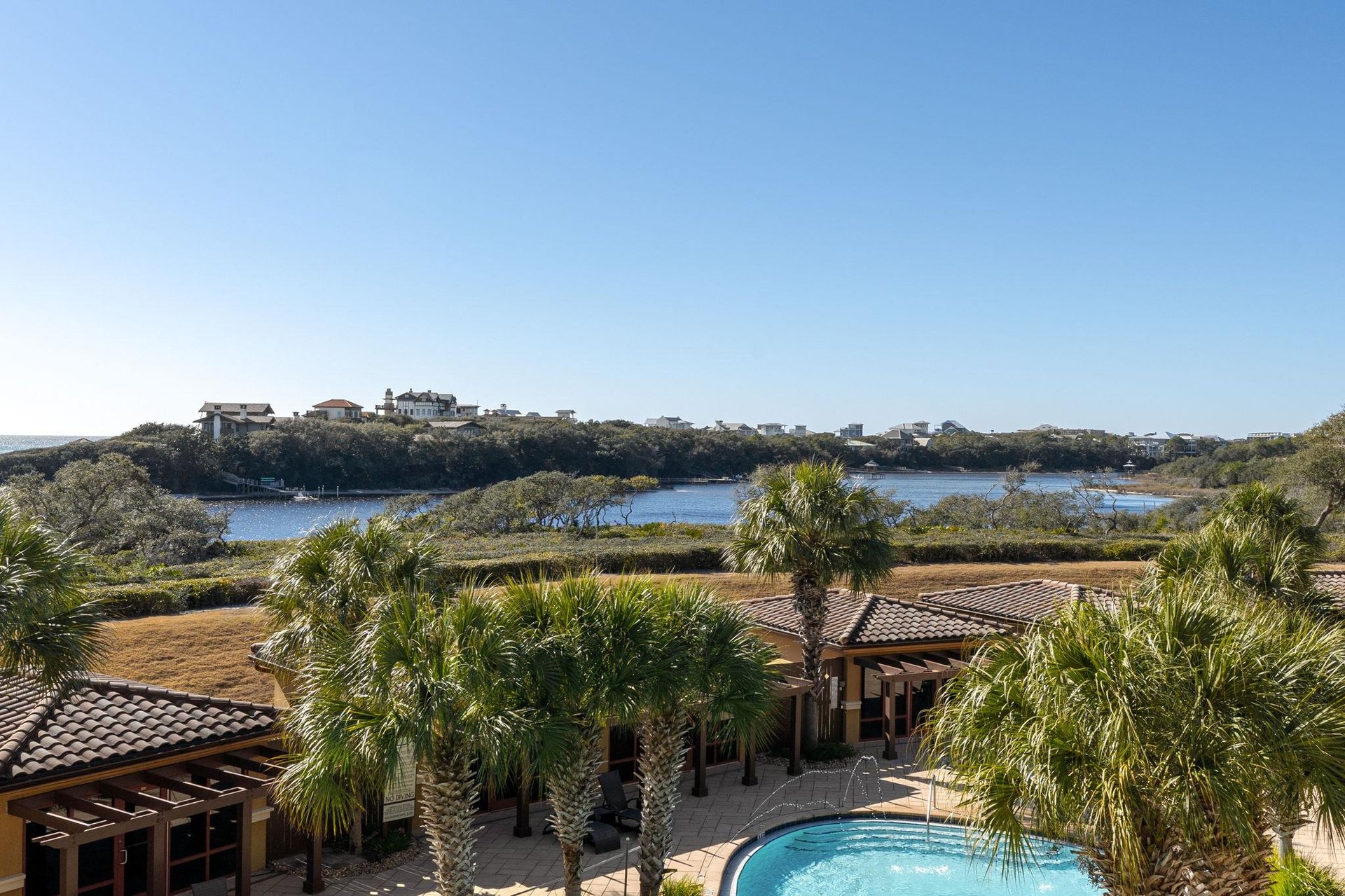 Coastal retreat with lake views and palmlined pool area surrounded by natural wetlands.