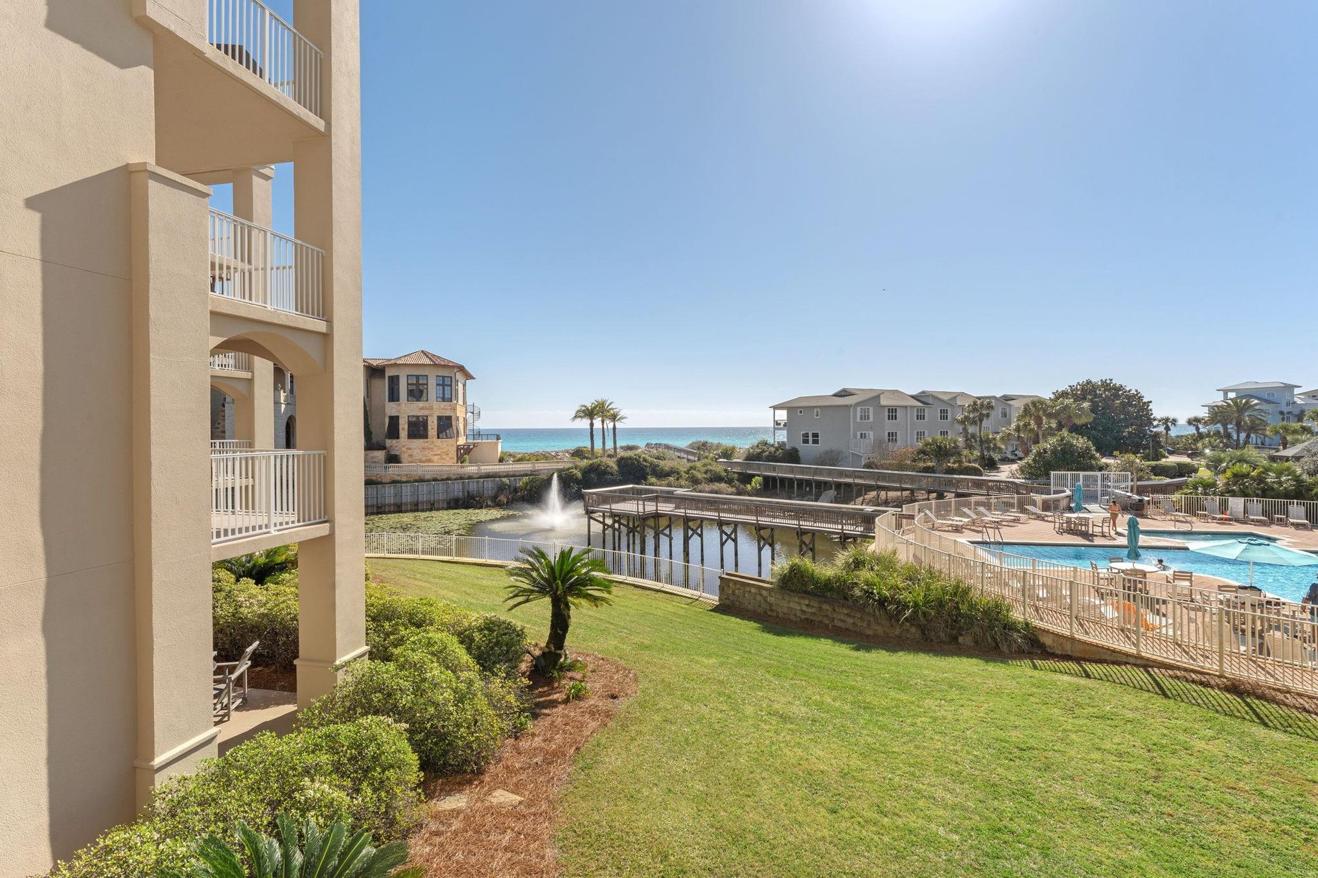Beachfront resort community with swimming pool, landscaped grounds, and coastal access via boardwalk.