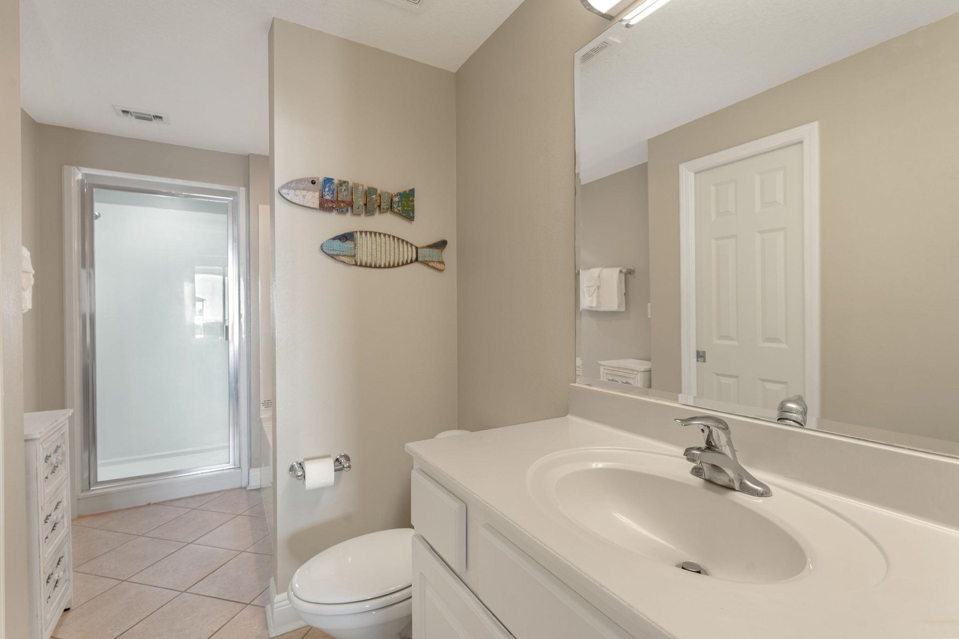 Step into the serene Primary bathroom with coastal touches and a refreshing shower to wash away the days adventures.