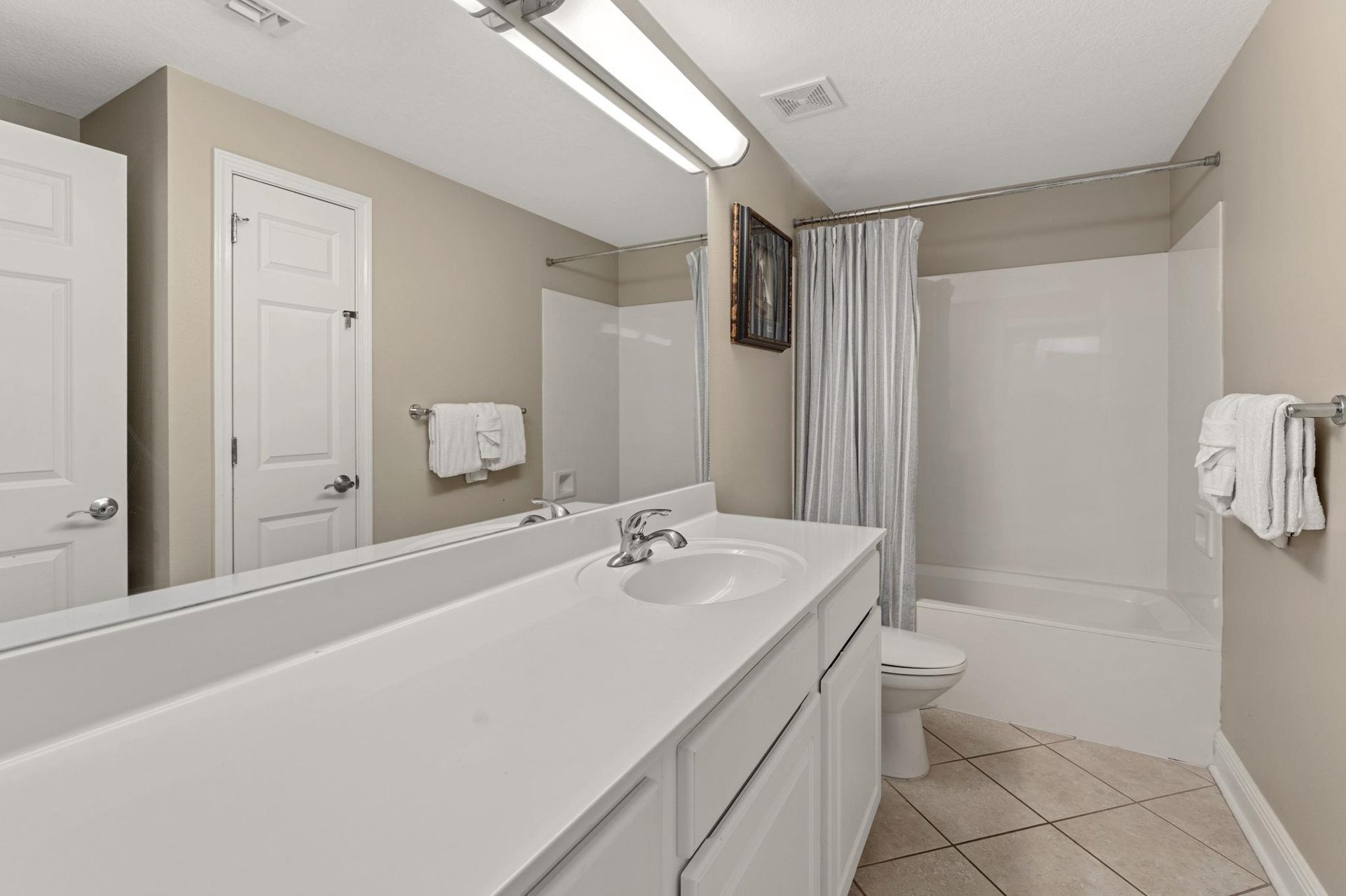 Spacious bathroom features a tub, fresh towels, and clean modern finishes for ultimate relaxation.