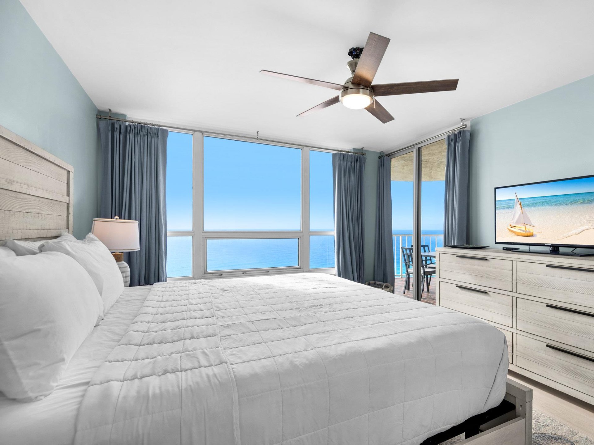 Bedroom 1  Wake up to endless ocean views from your serene bedroom, where soft blue walls and crisp linens create your perfect coastal retreat.