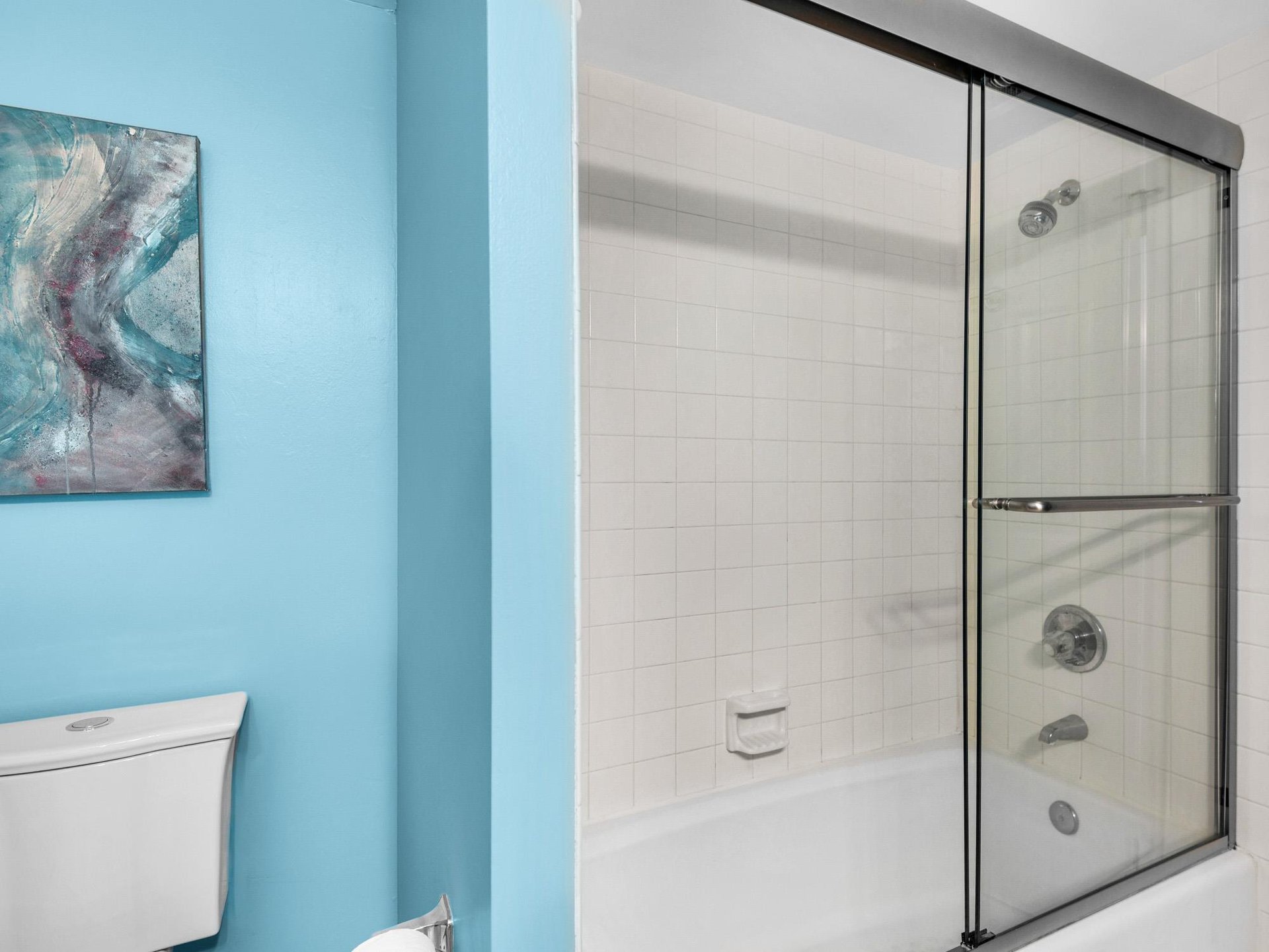 Bathroom 2 Refresh in your bright bathroom with spacious shower and clean modern fixtures, featuring soothing blue walls.