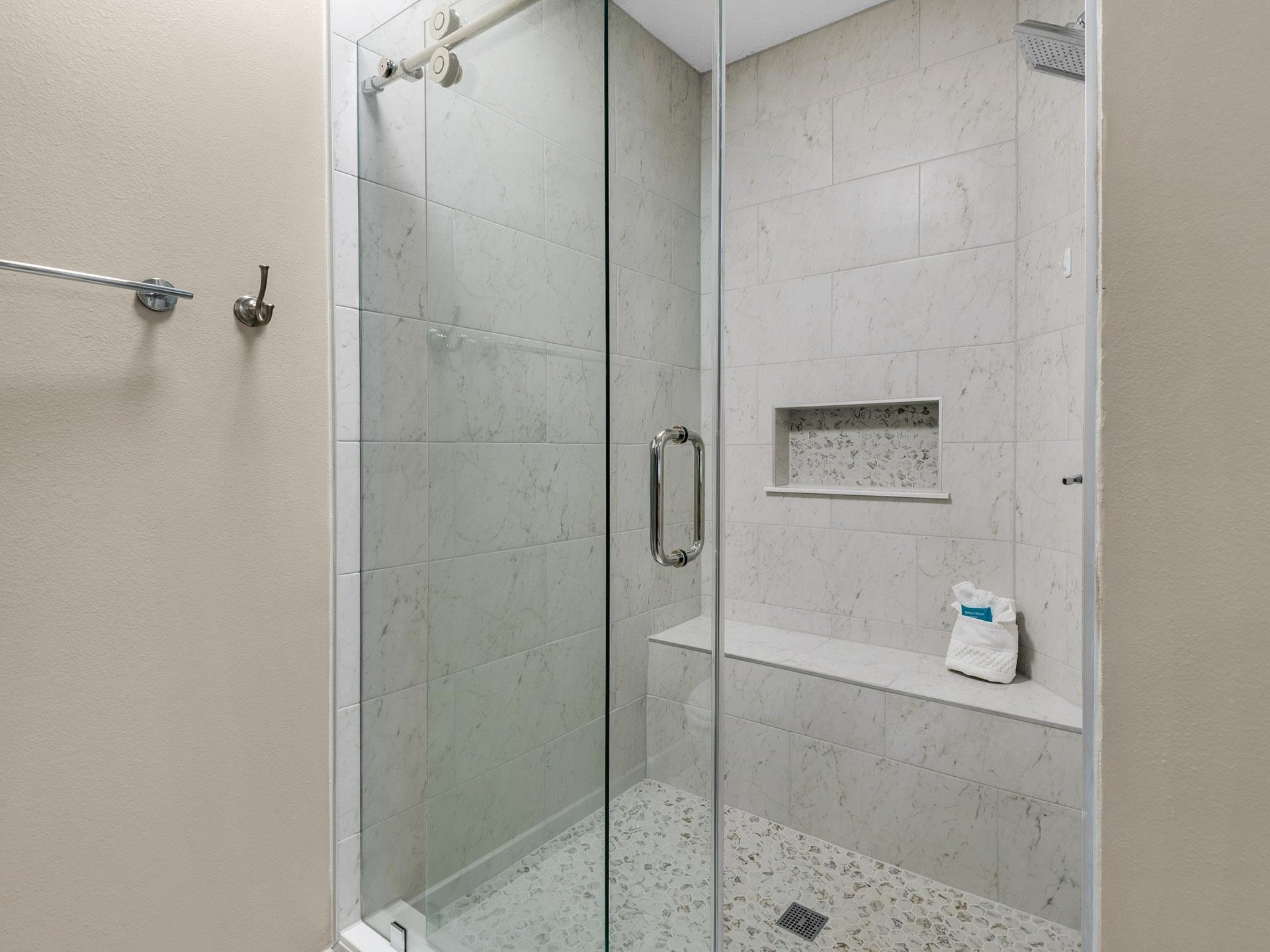 Bathroom 1 Step into your luxurious marbletiled shower with sleek glass doors, rainfall head, and builtin bench for a spalike experience.