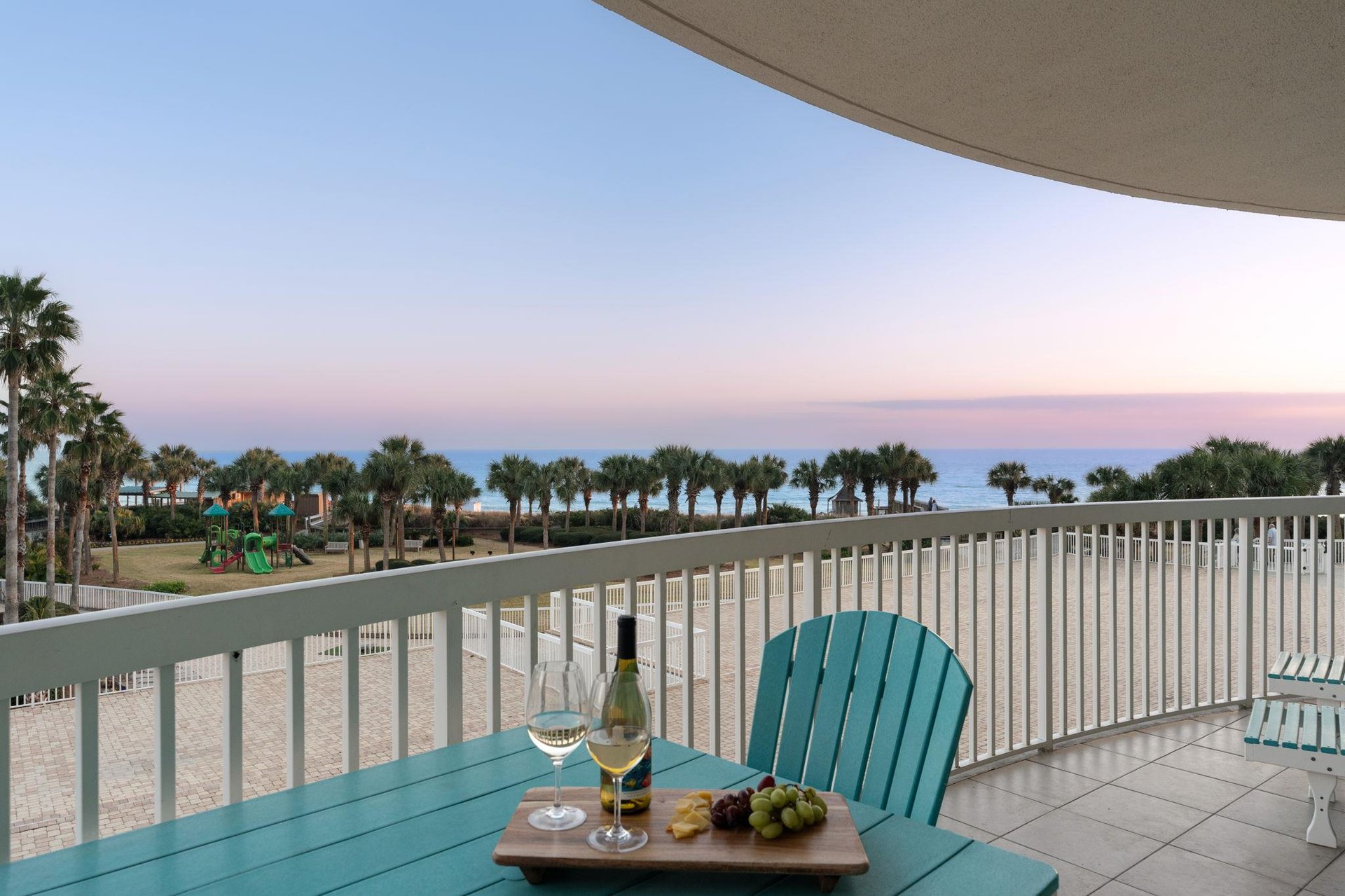 Unwind on your private balcony with wine and snacks as sunset paints the sky over swaying palms and pristine beachfront.