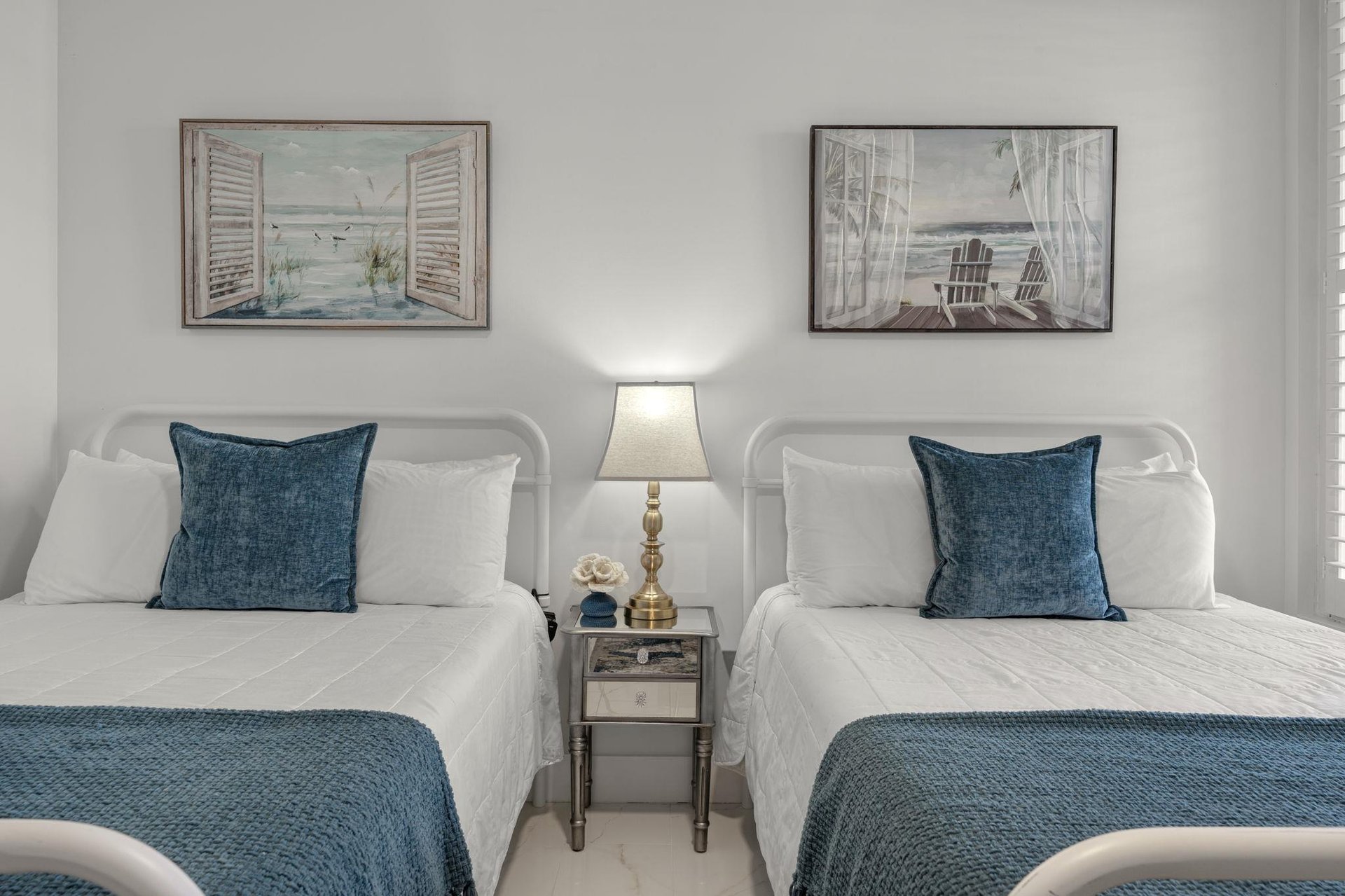 Relax in your coastalthemed double bedroom, featuring crisp white linens and soothing blue accents that mirror the serene artwork above.