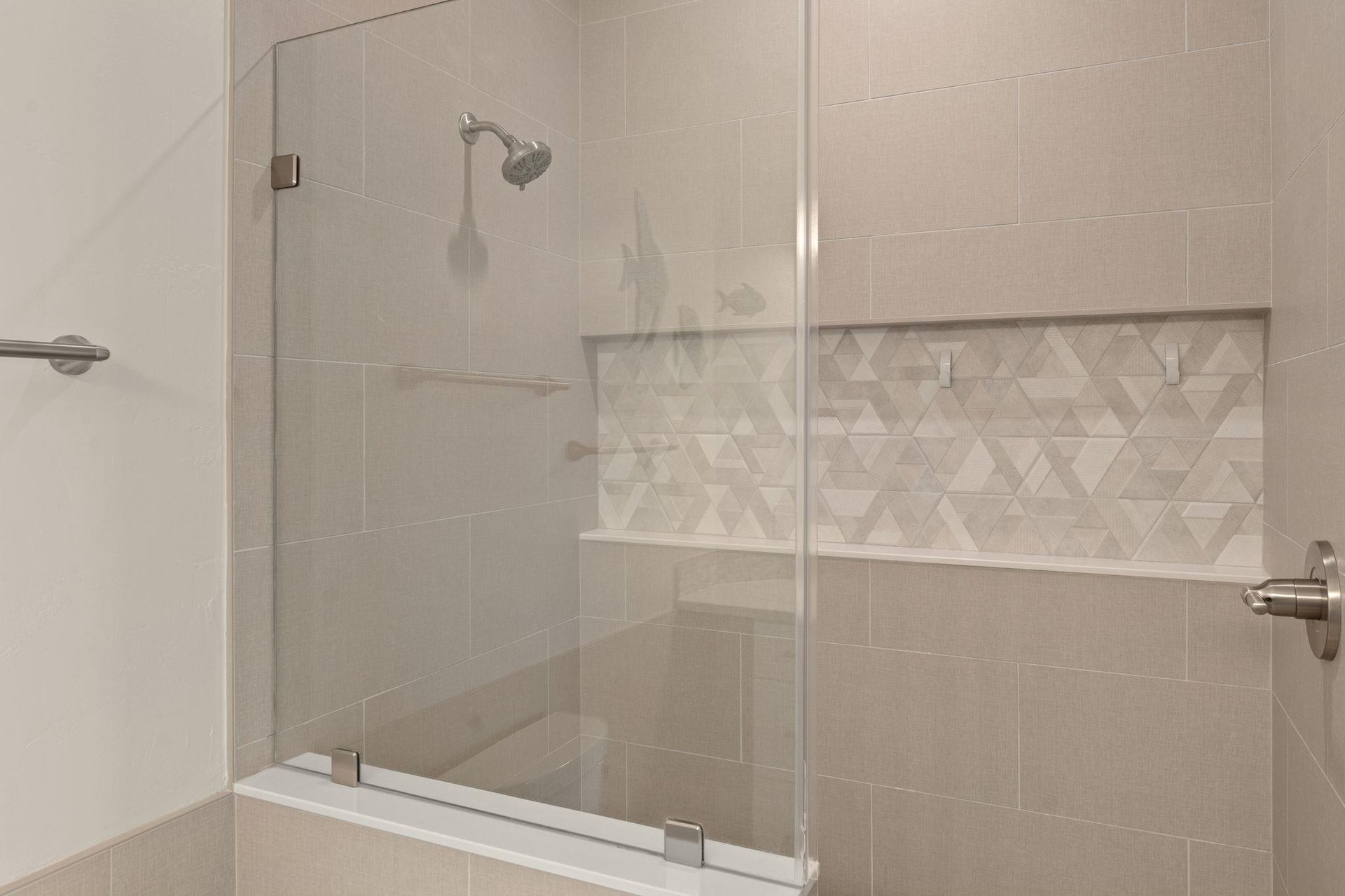 Step into your private spalike shower with elegant glass doors, designer tiling, and a builtin bench for ultimate relaxation.