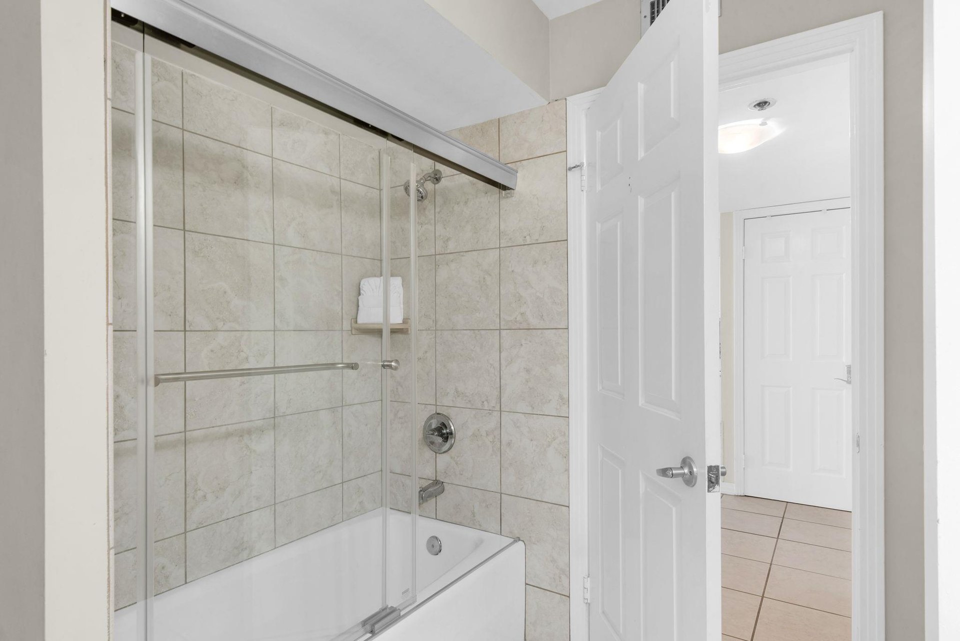 Step into your elegant bathroom featuring a spacious tubshower combo with marblelook tile and convenient grab bar for comfort.