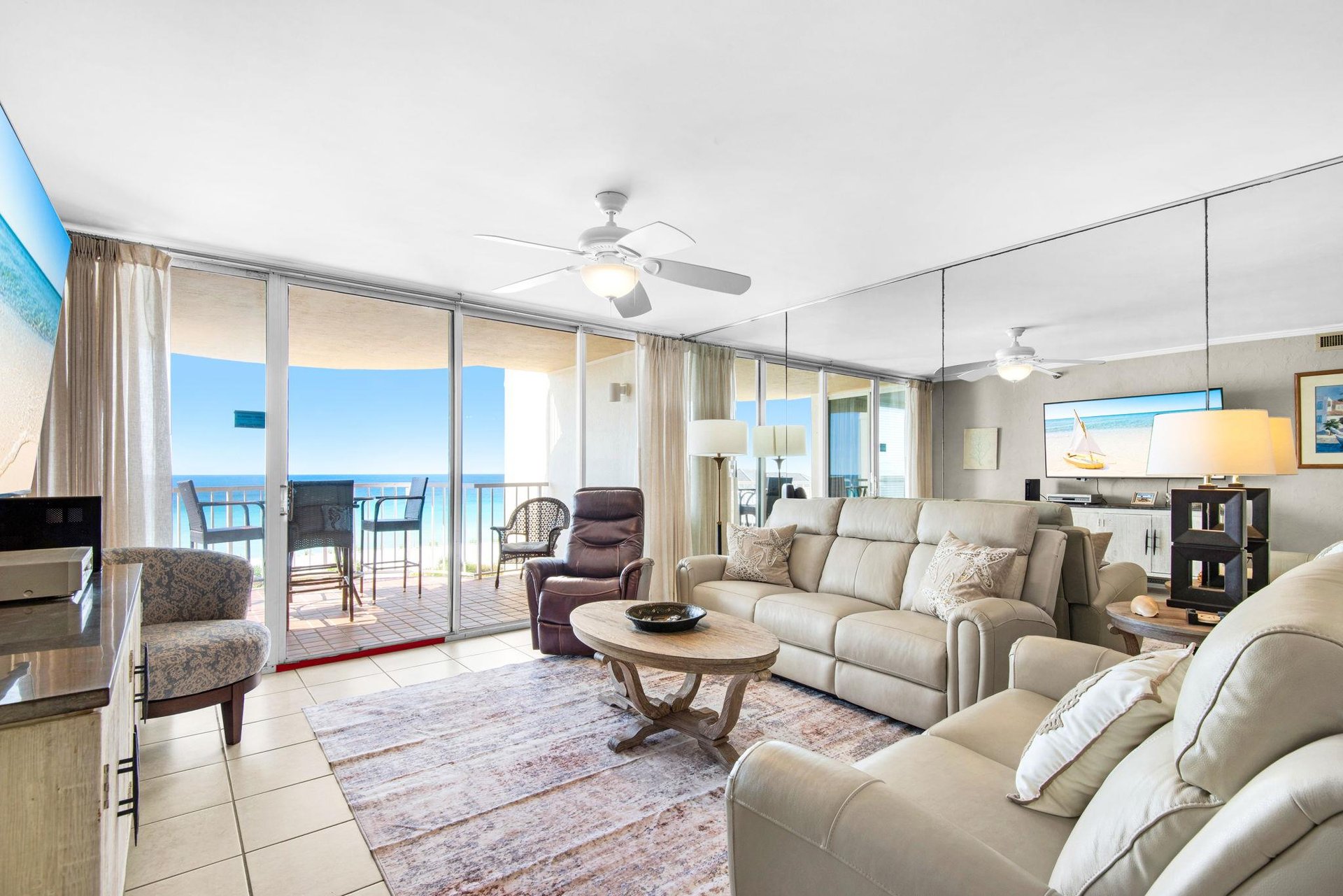 Unwind in your bright oceanfront living room with plush leather seating and stunning sea views stretching endlessly beyond your private balcony.
