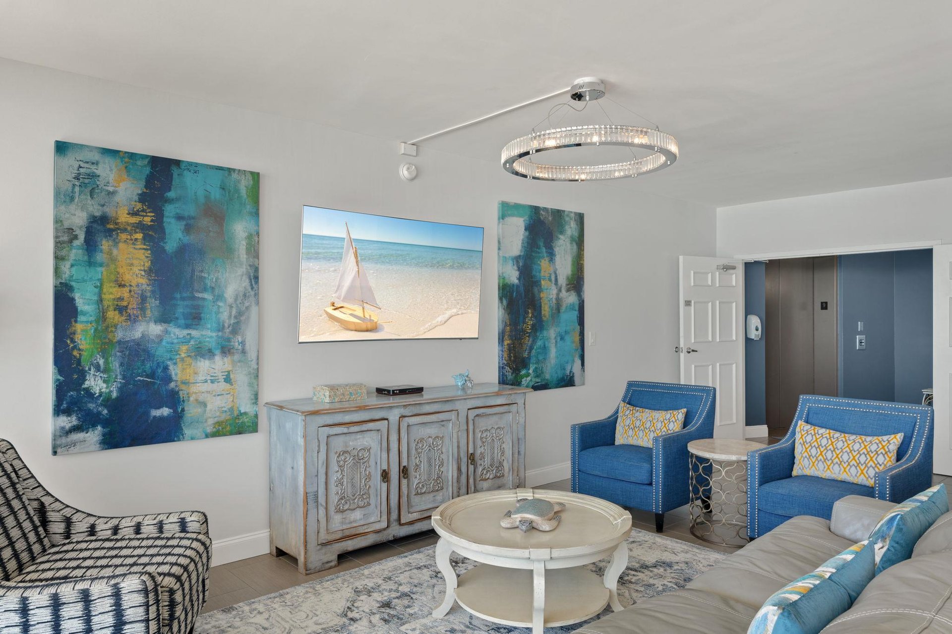 Sink into elegant comfort in your sophisticated living room, where coastal artwork and plush seating create the perfect space to unwind after beach days.