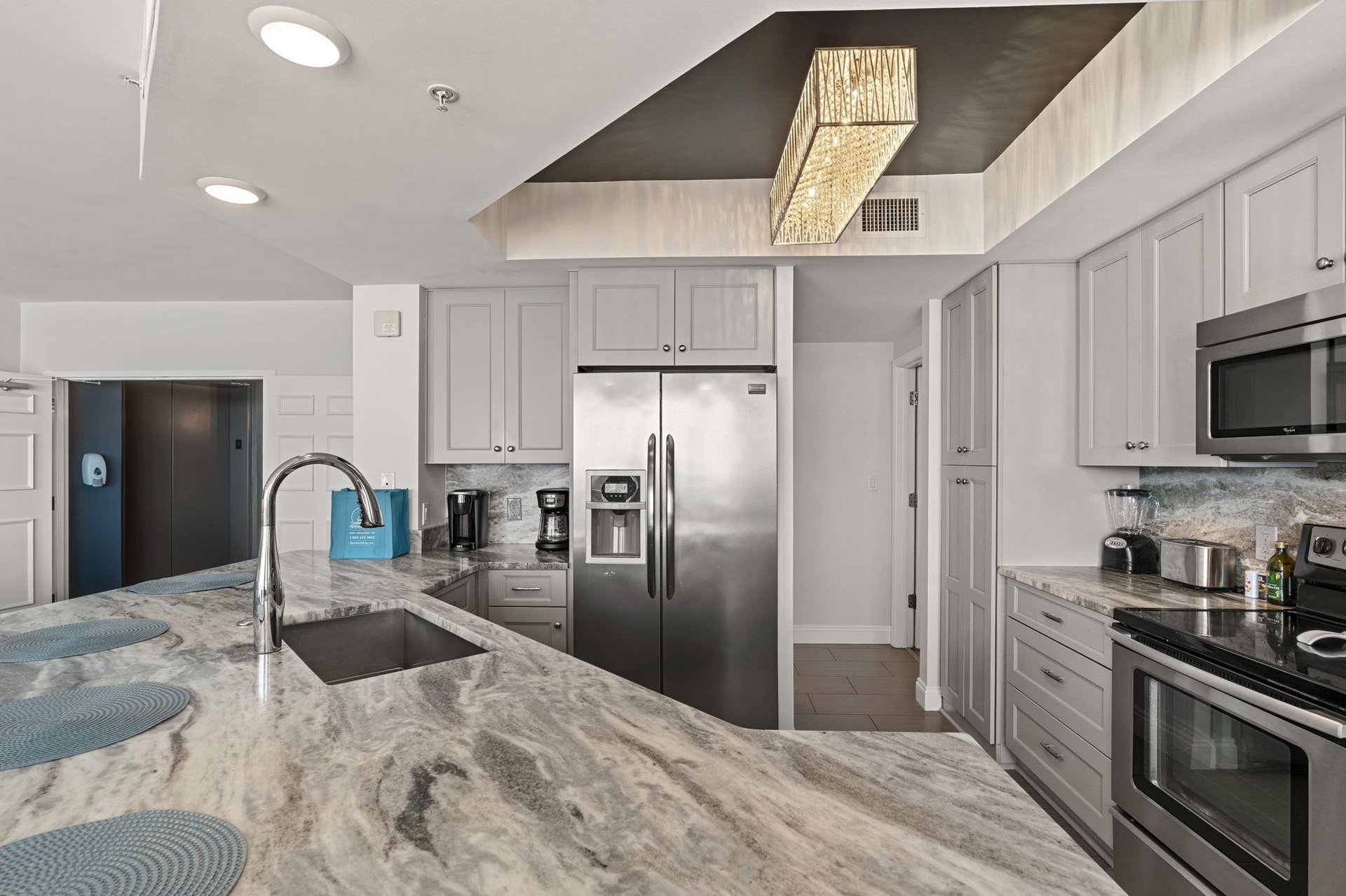 Your gourmet kitchen awaits with stunning marble countertops, stainless steel appliances, and elegant gray cabinetry—perfect for creating memorable meals during your stay.