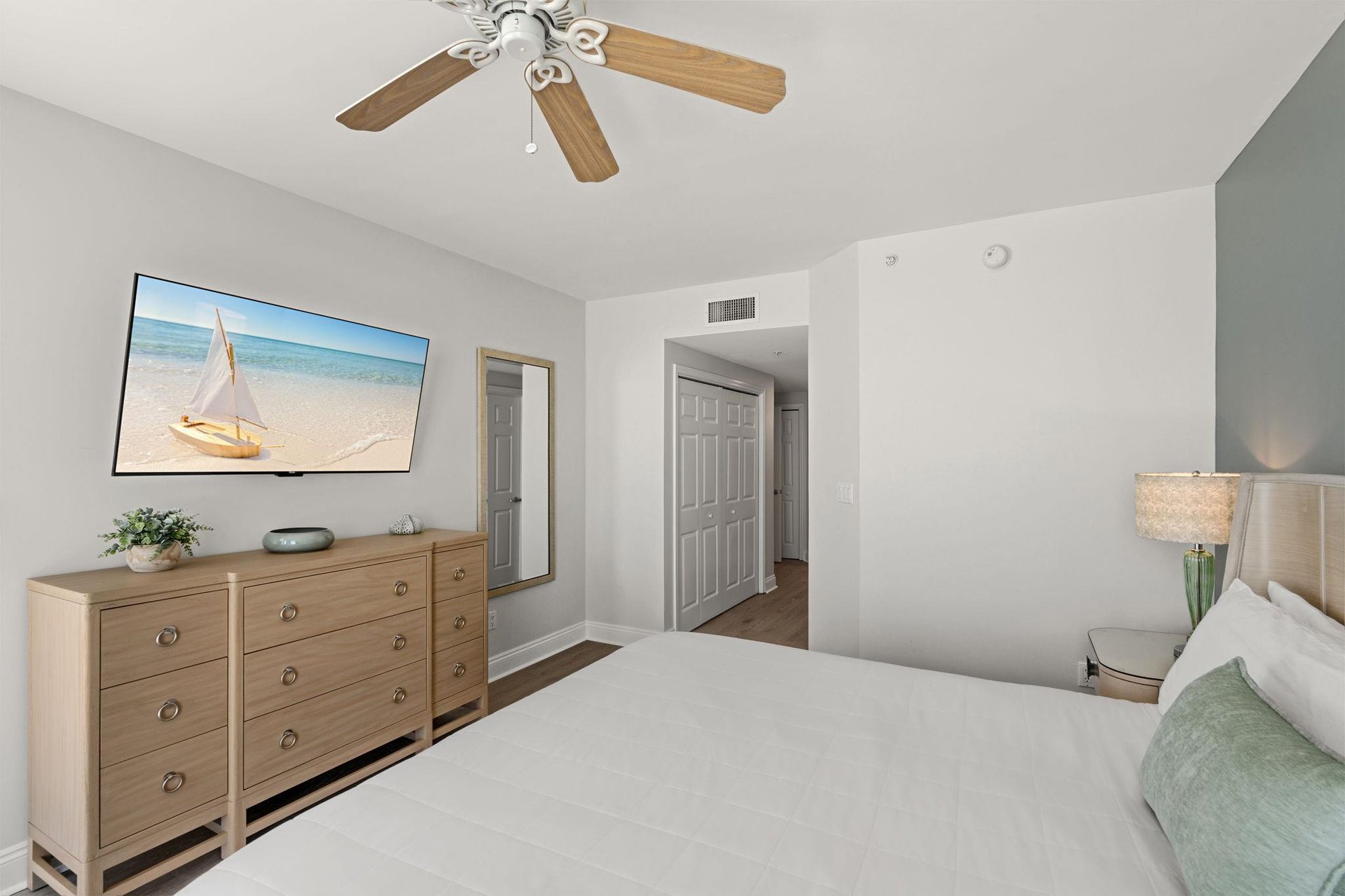 Unwind in your peaceful bedroom where coastal artwork and soft lighting create the perfect atmosphere for restful nights and relaxed mornings.