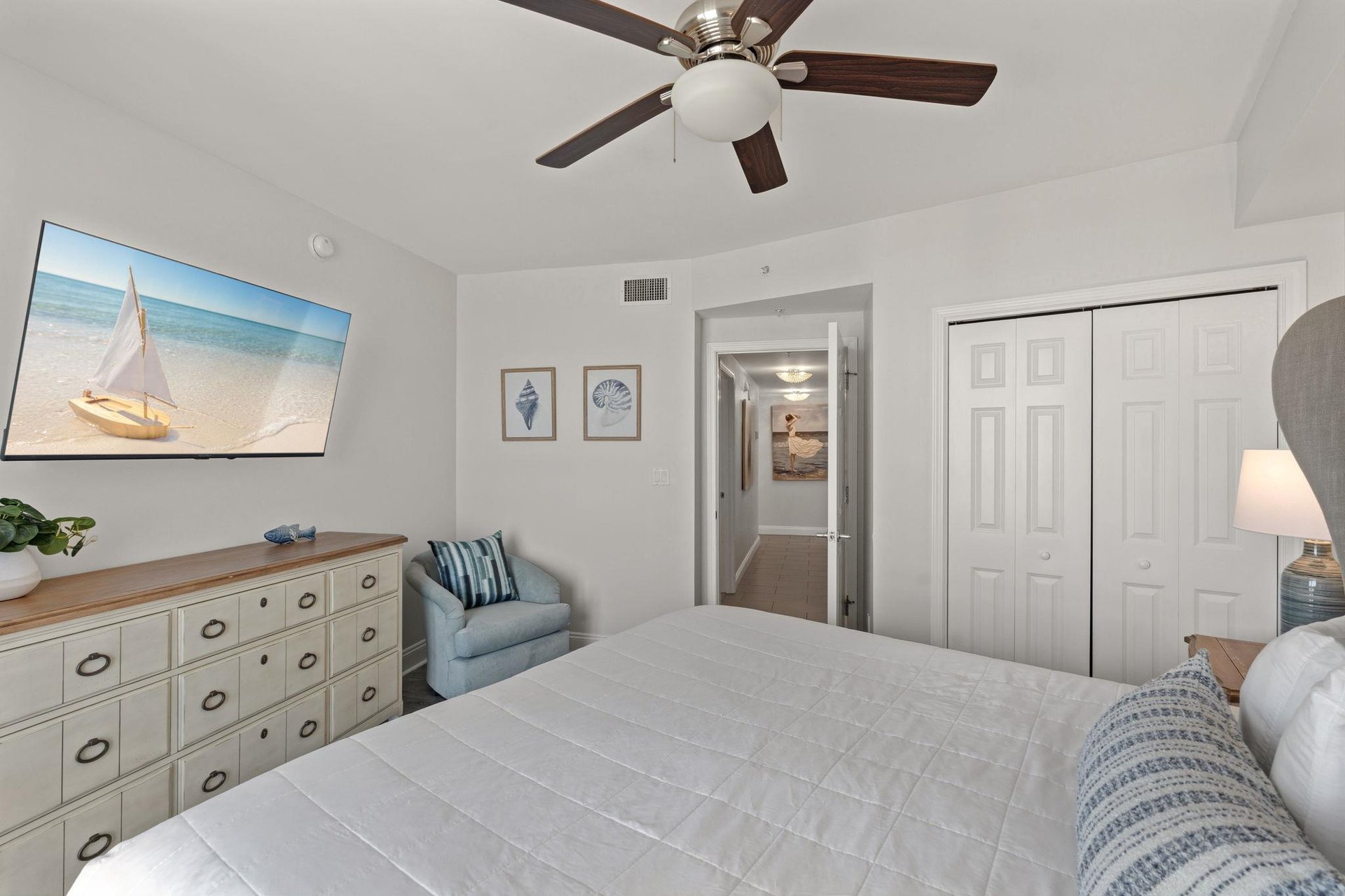 Unwind in your coastalthemed bedroom with nautical touches, ceiling fan comfort, and peaceful seaside artwork to inspire restful nights.