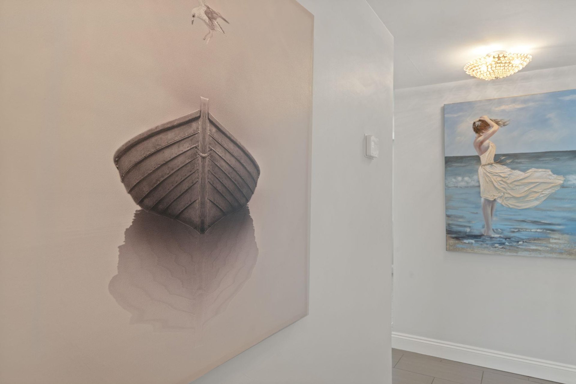 Elegant coastal artwork creates a serene atmosphere in your stylish hallway, featuring beautiful seainspired paintings that set a peaceful mood.