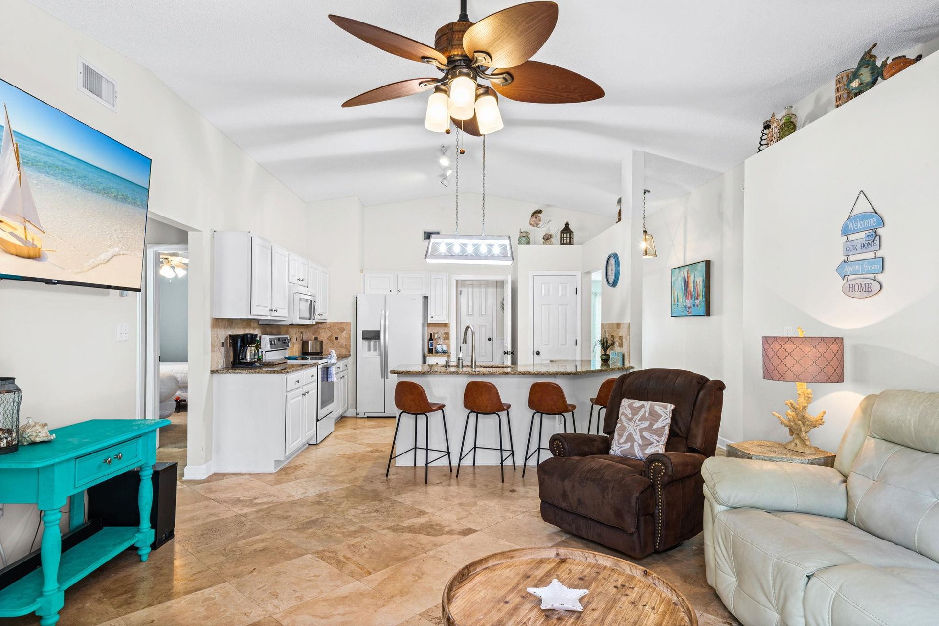 Relax in your bright, coastalthemed living space where turquoise accents and beach art create a vacation vibe.