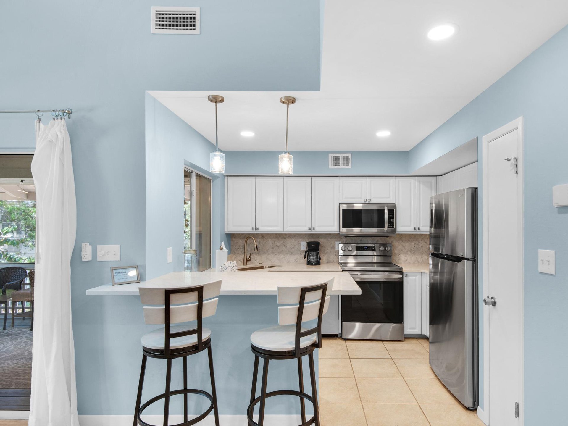 Your modern kitchen features sleek white cabinets, stainless steel appliances, and a breakfast bar for casual meals.